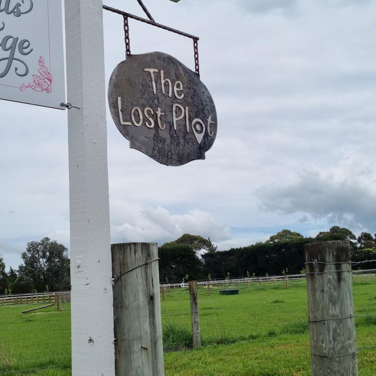 A sign for the lost plot hangs over a grassy field.