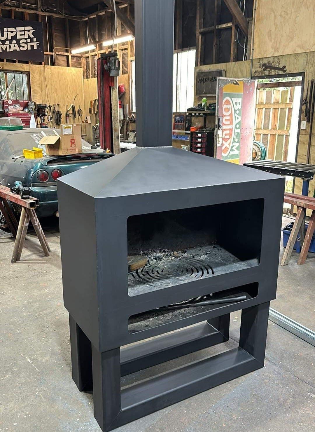 A large black fireplace is sitting in a warehouse.
