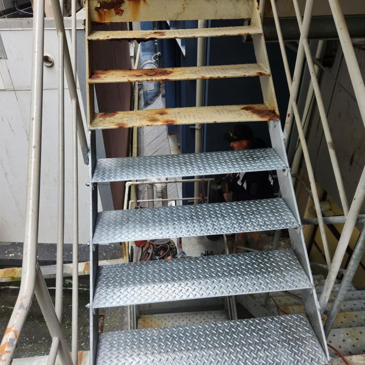 A metal staircase with a diamond pattern on the steps.