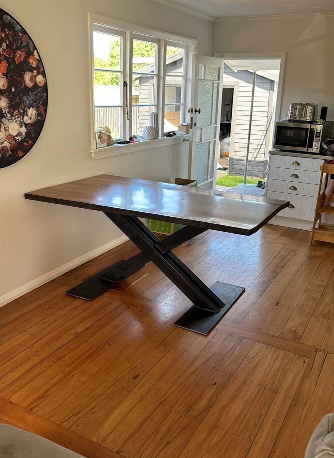 A wooden table is sitting in a living room next to a window.