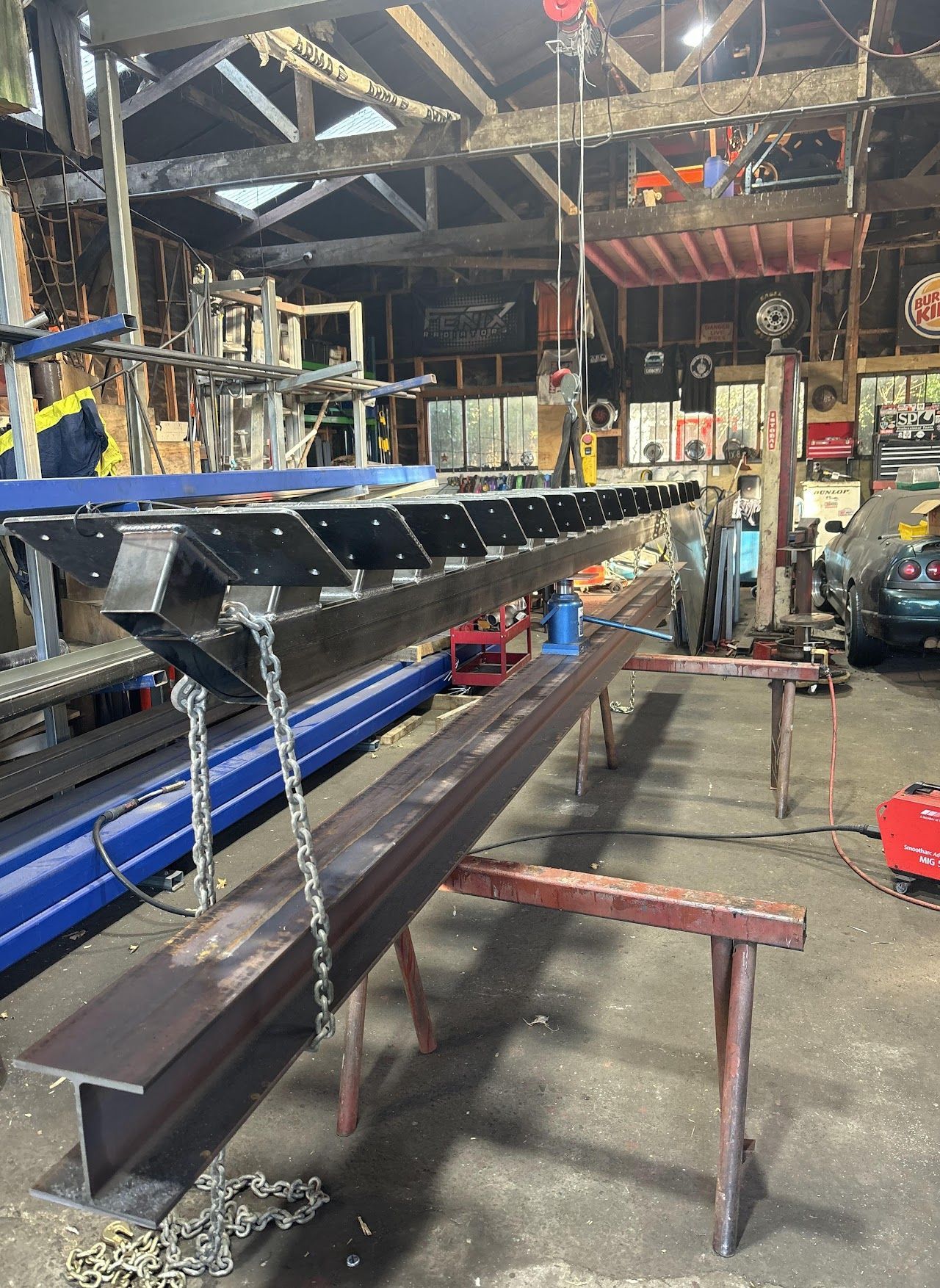 A large piece of metal is hanging from chains in a workshop.