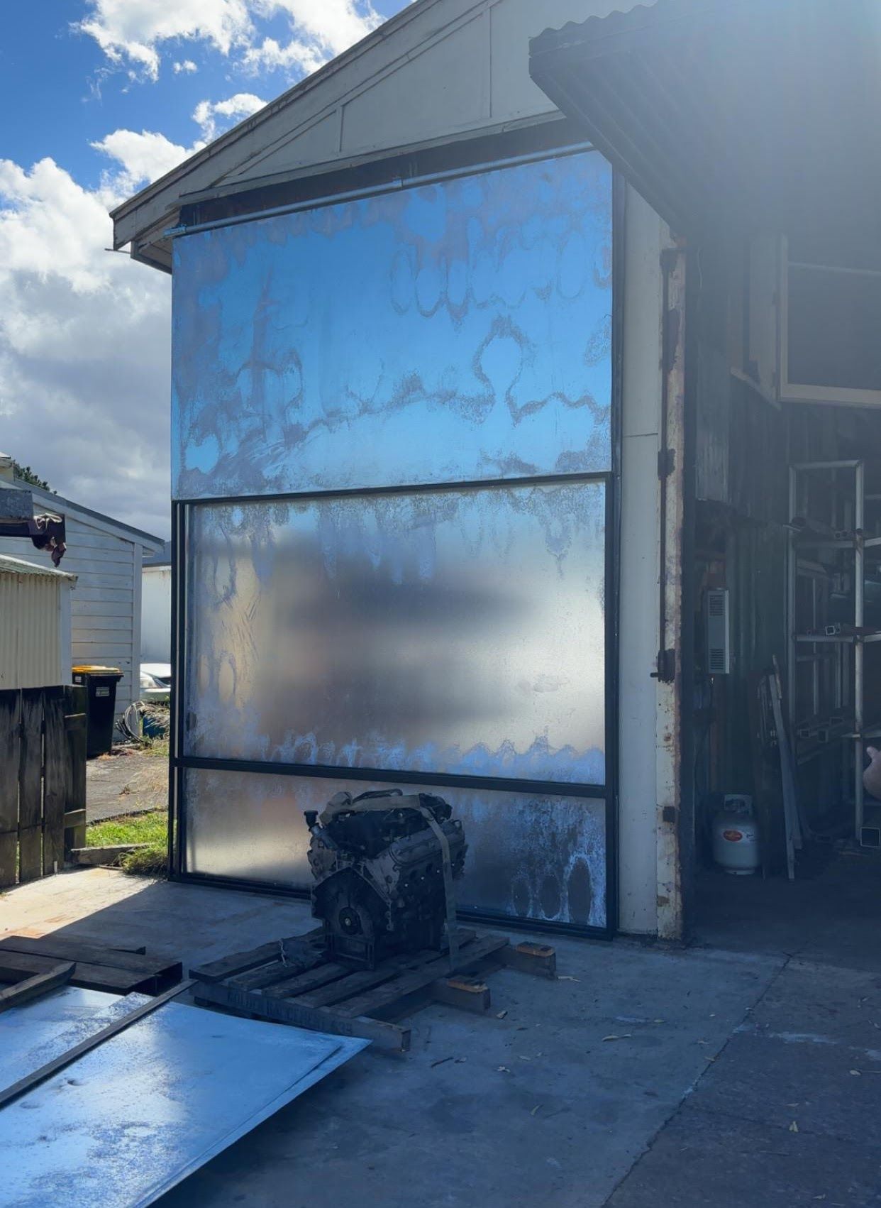 A large metal wall is sitting in front of a building.