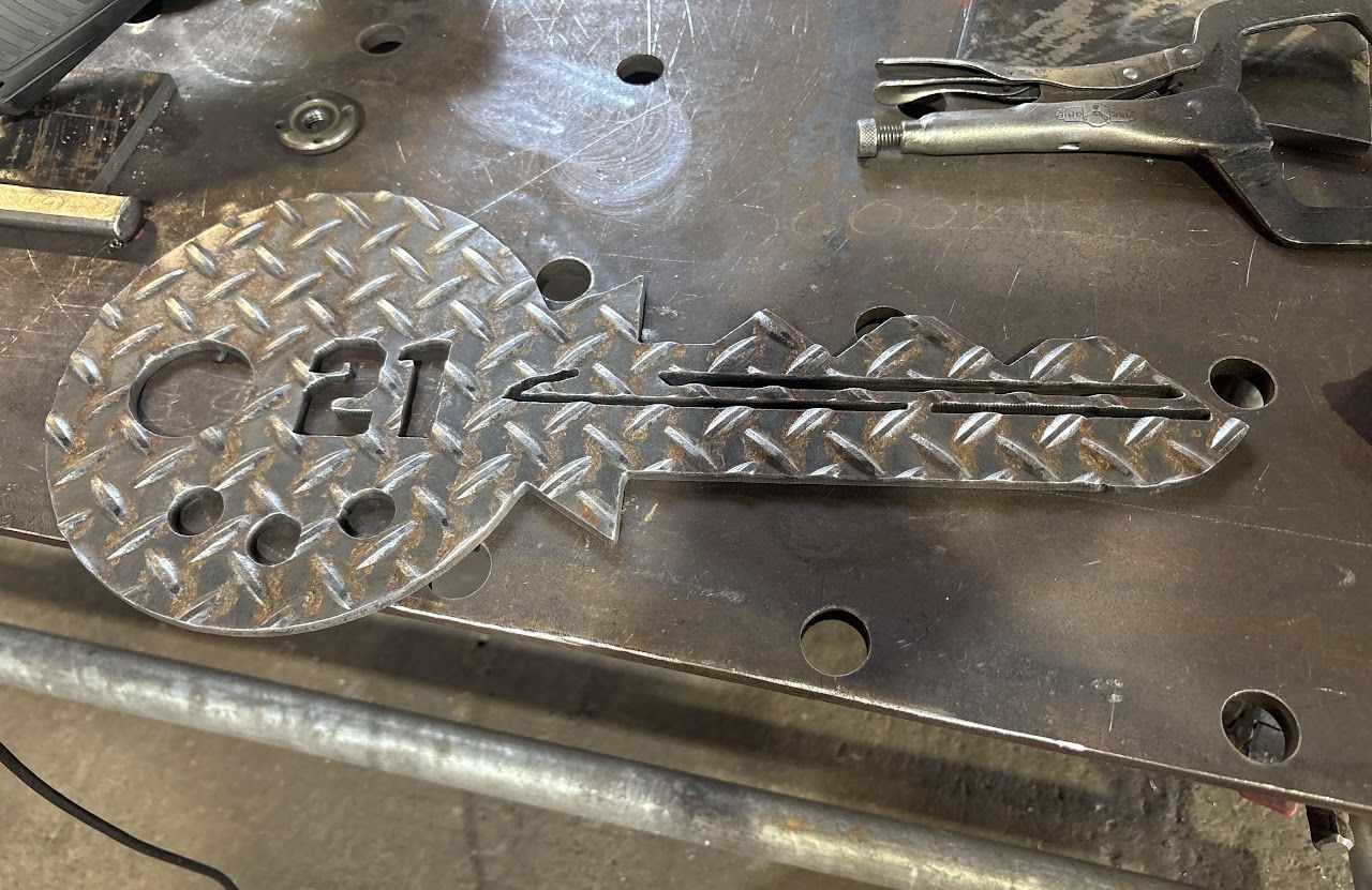 A metal key is sitting on top of a metal table.