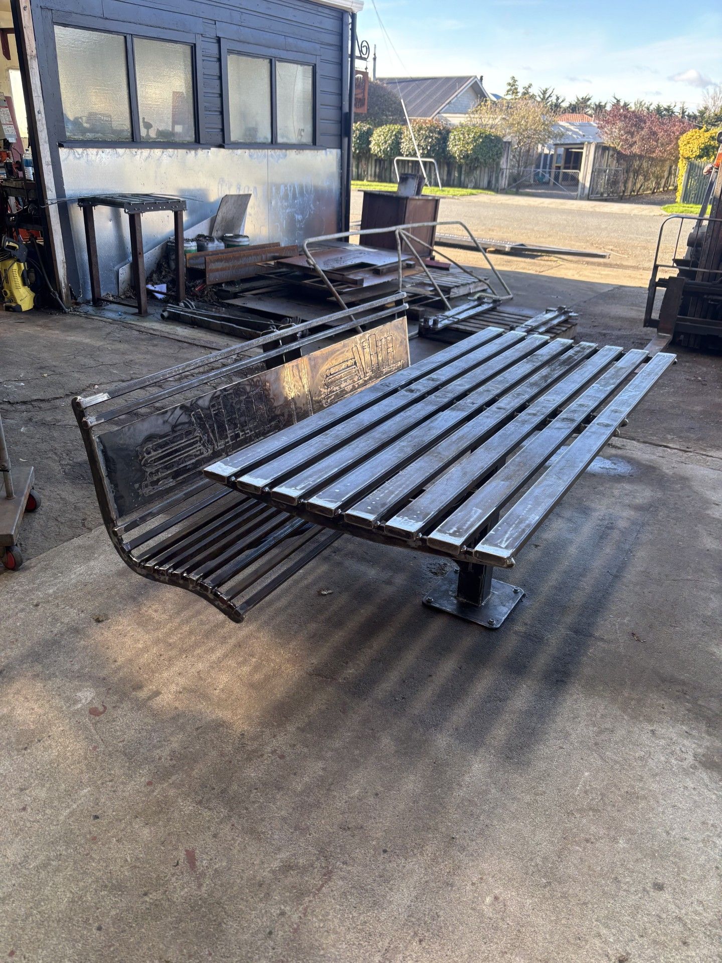 A wooden bench is sitting on the ground in front of a building.