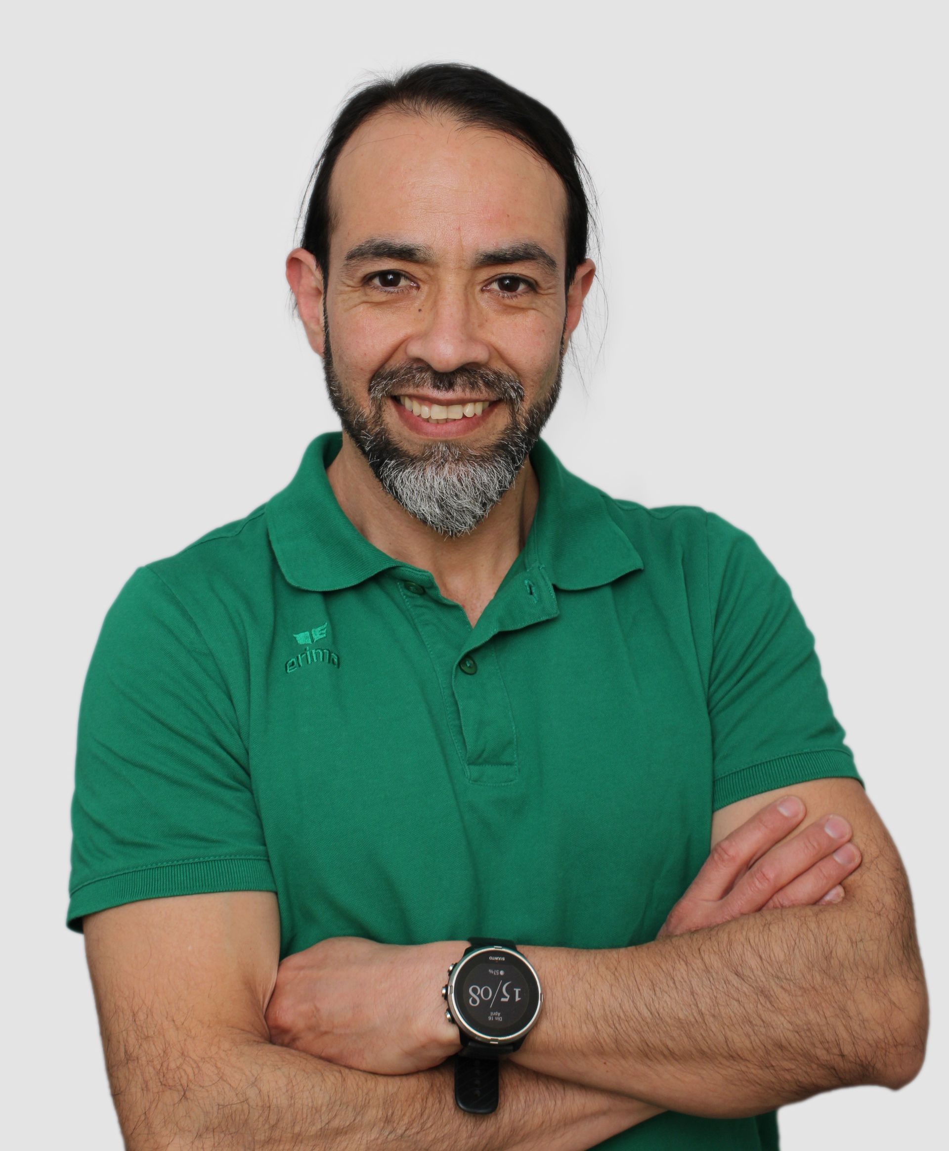 Een man met een baard draagt ​​een groen poloshirt en een horloge.