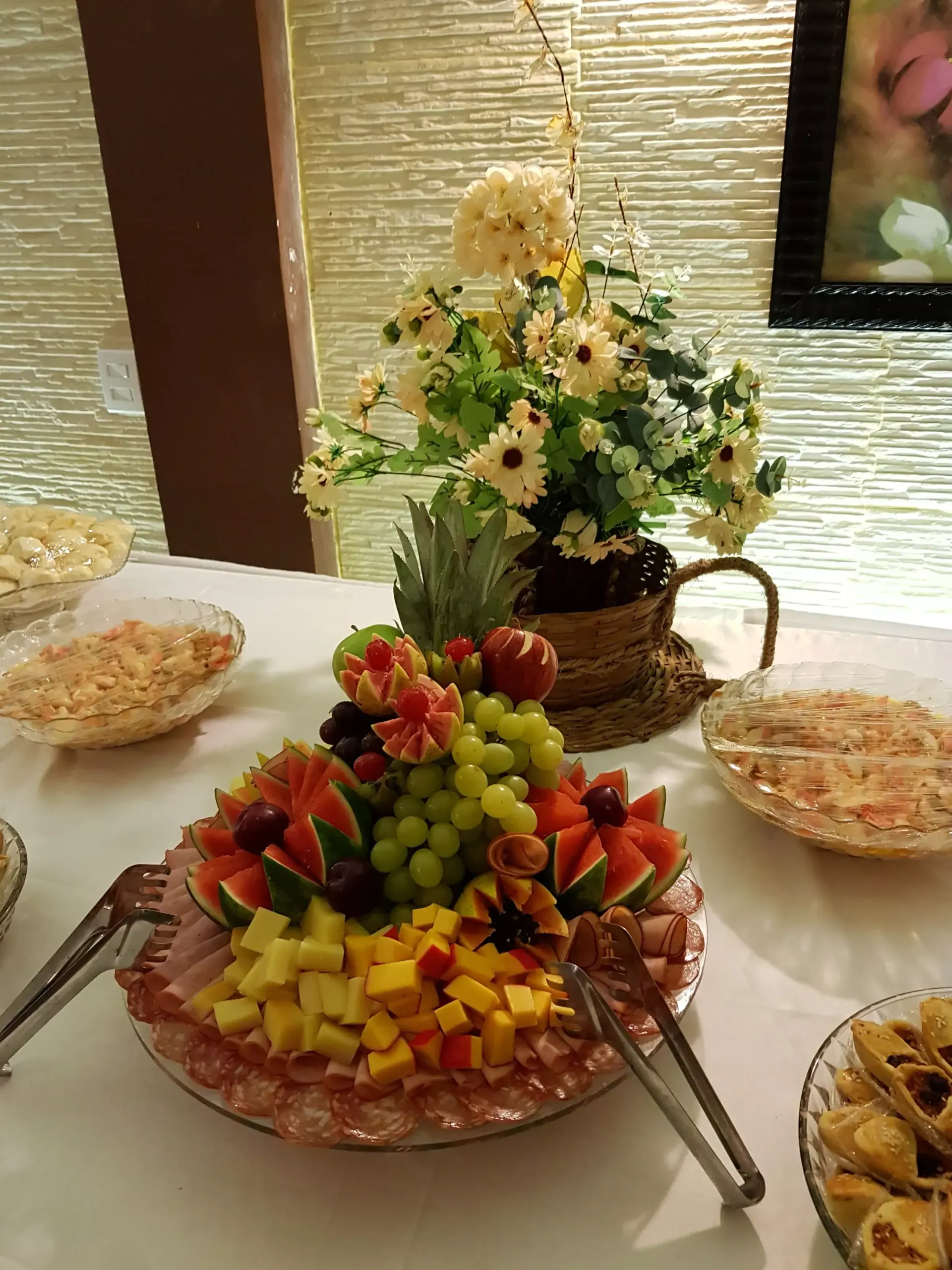 Uma mesa coberta com pratos de comida e um vaso de flores.-Pousada Águas de Piruí