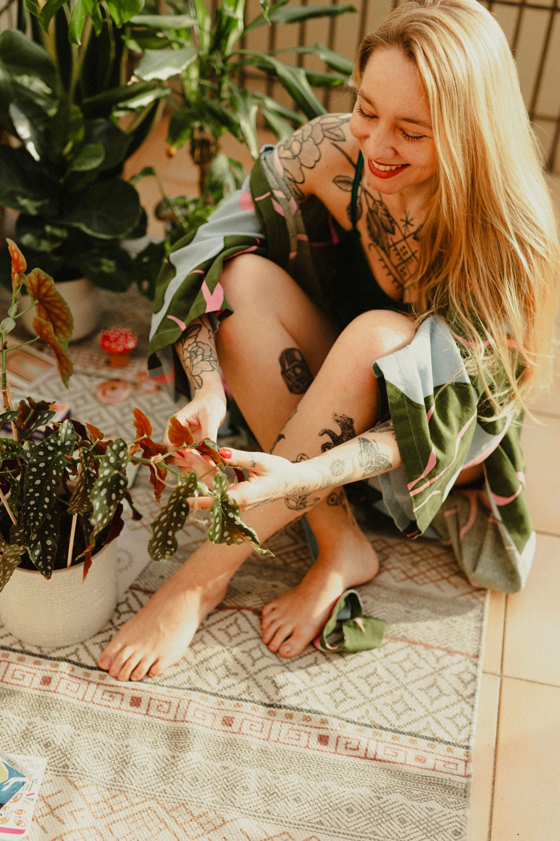 Uma mulher está sentada no chão segurando um vaso de planta.