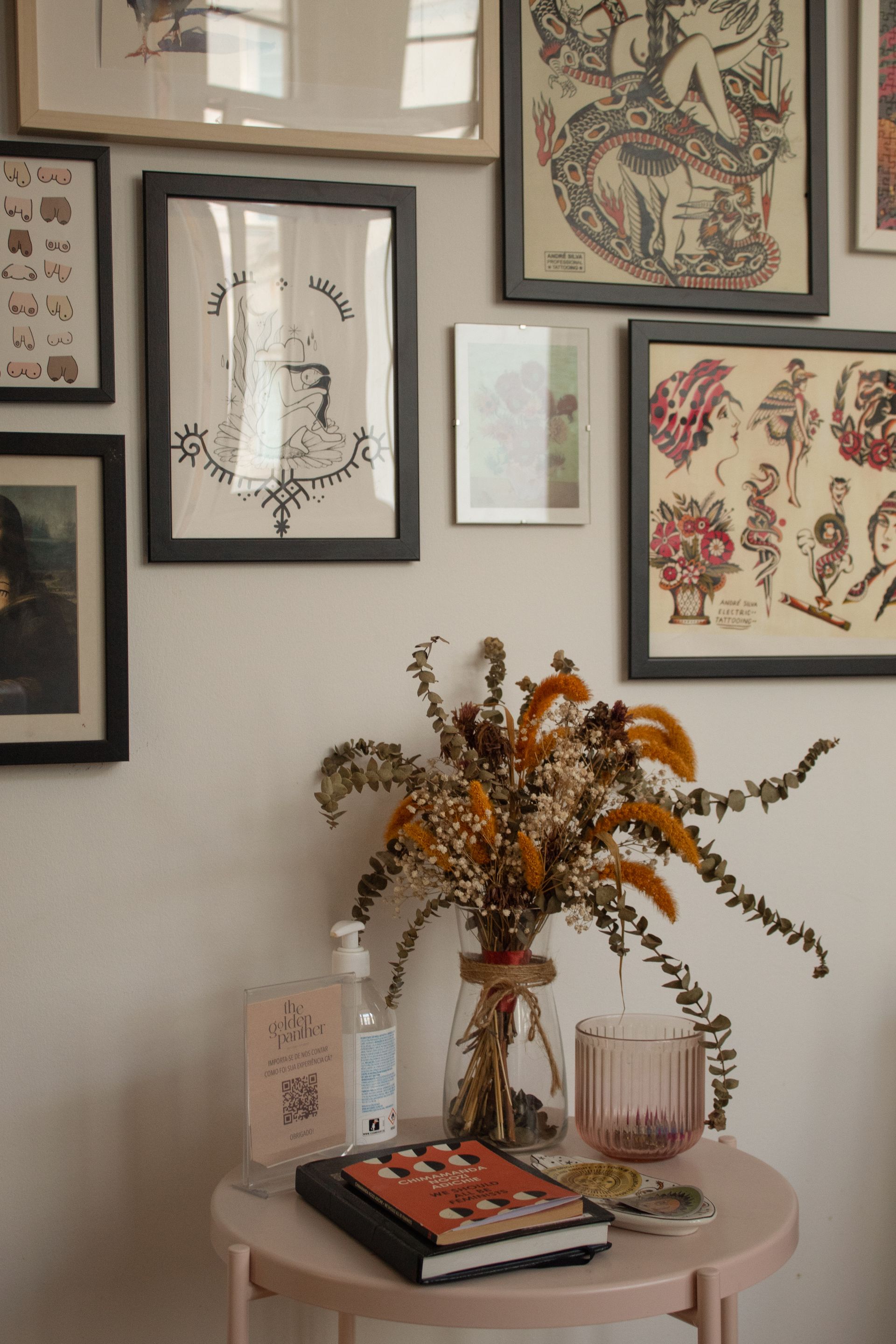 Uma mesa com um vaso de flores secas e um livro sobre ela.