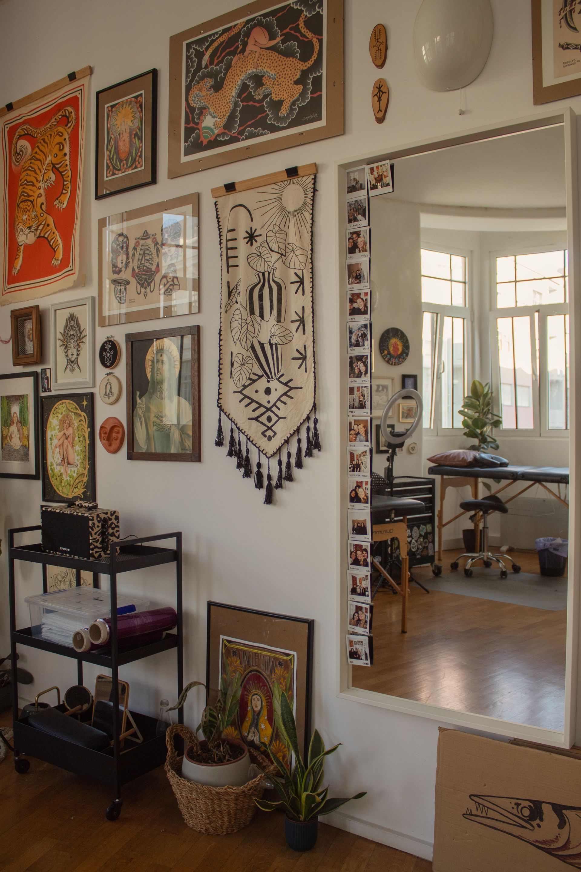 Uma sala com muitas fotos na parede e um espelho grande