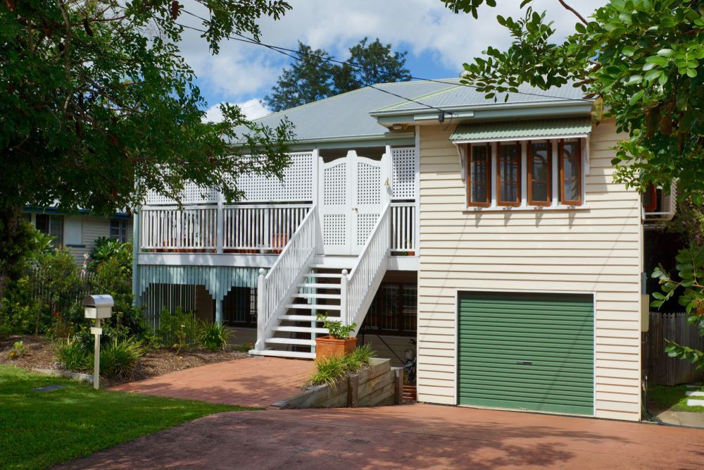 Two-story Cream House With Green Garage Door — Northern Demolition and Civils in Garbutt, QLD