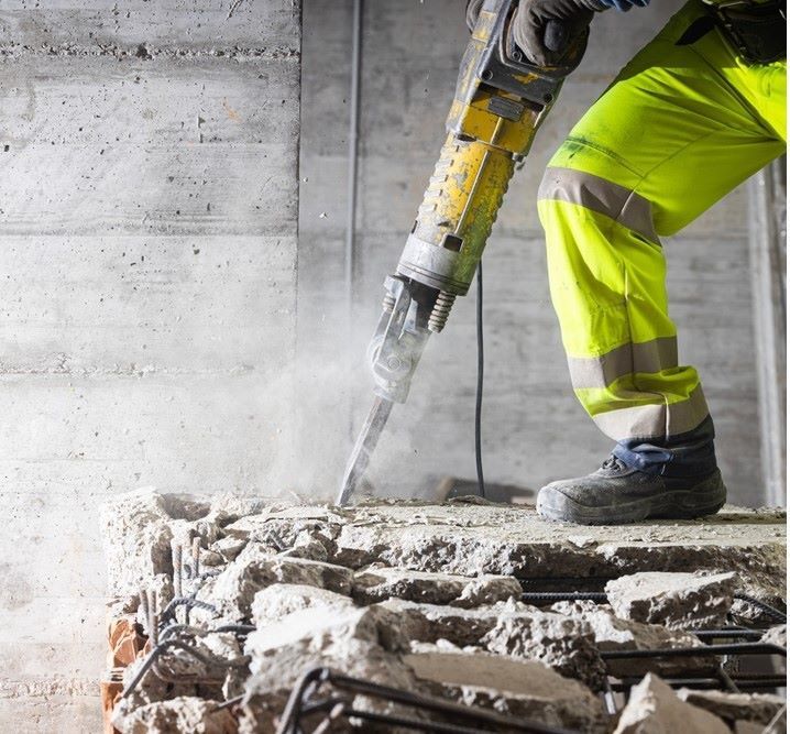 A Construction Worker Is Using A Hammer To Break Concrete — Northern Demolition and Civils in Innisfail, QLD
