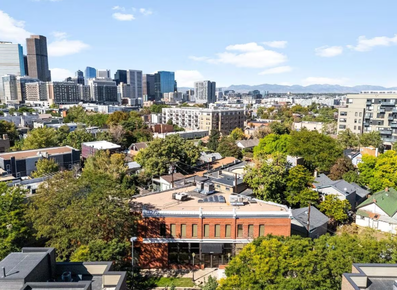 Skyscrapers with reflective blue glass facades dominate a city skyline under a cloudy sky.