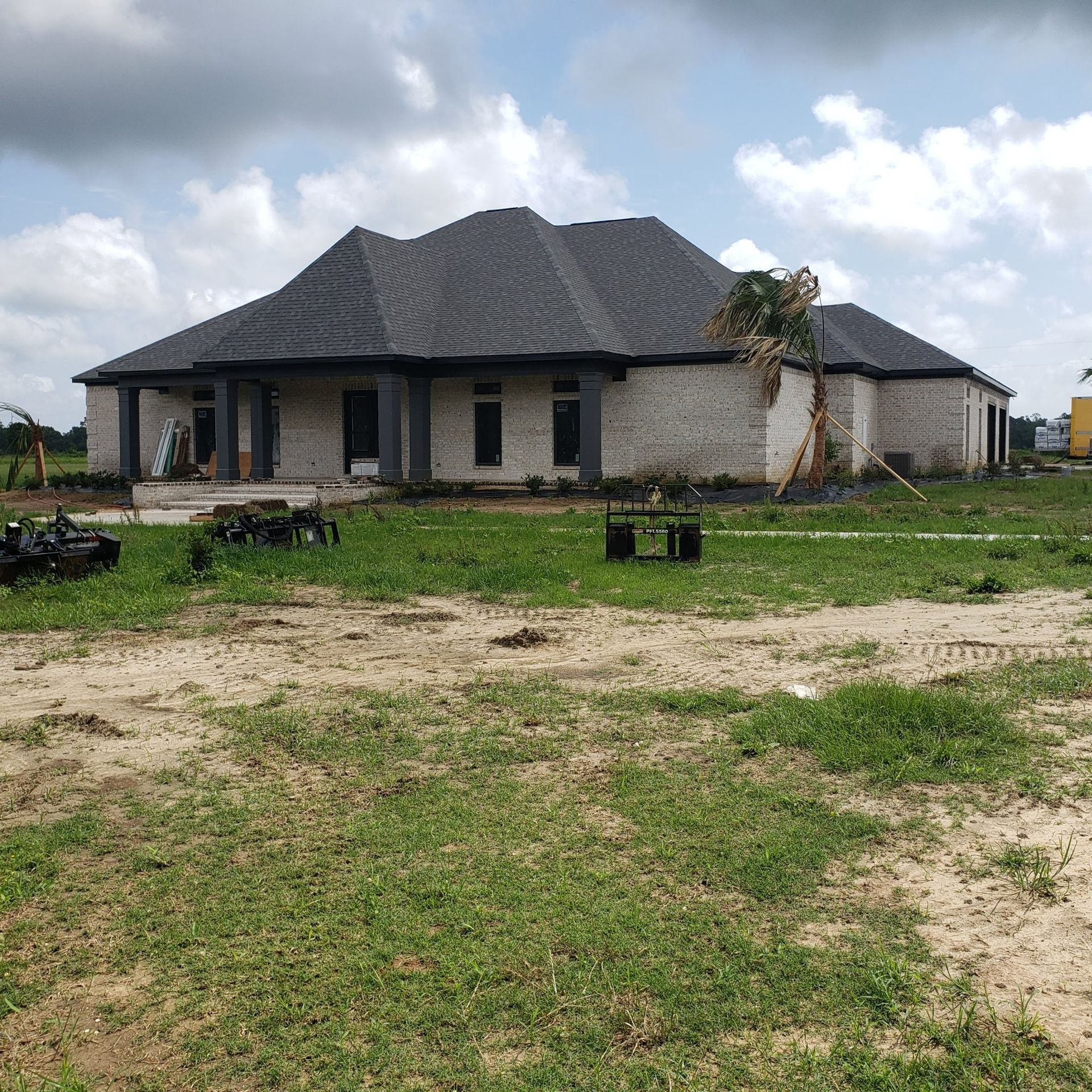 A large house is sitting in the middle of a grassy field.