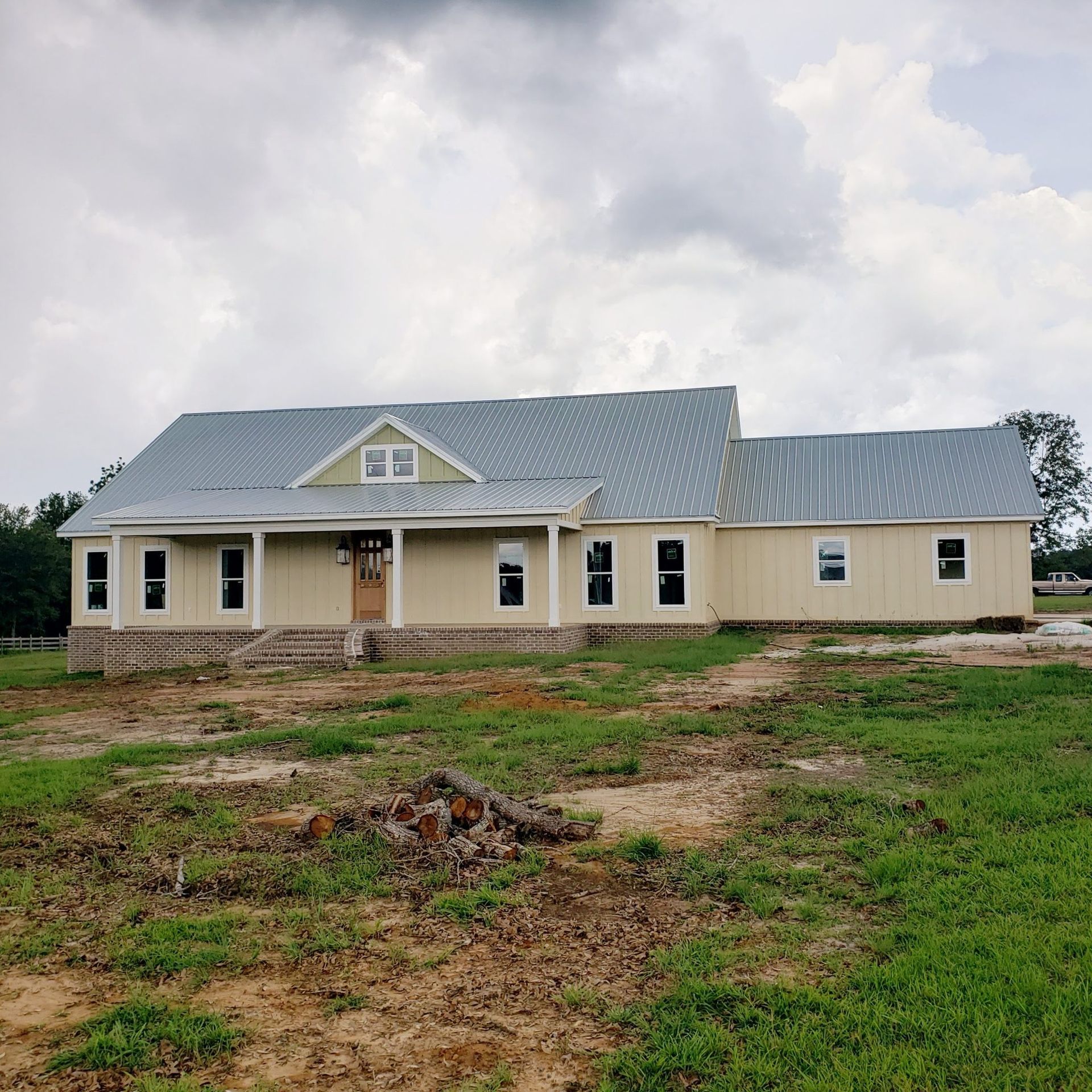 A large house with a blue roof is in the middle of a grassy field