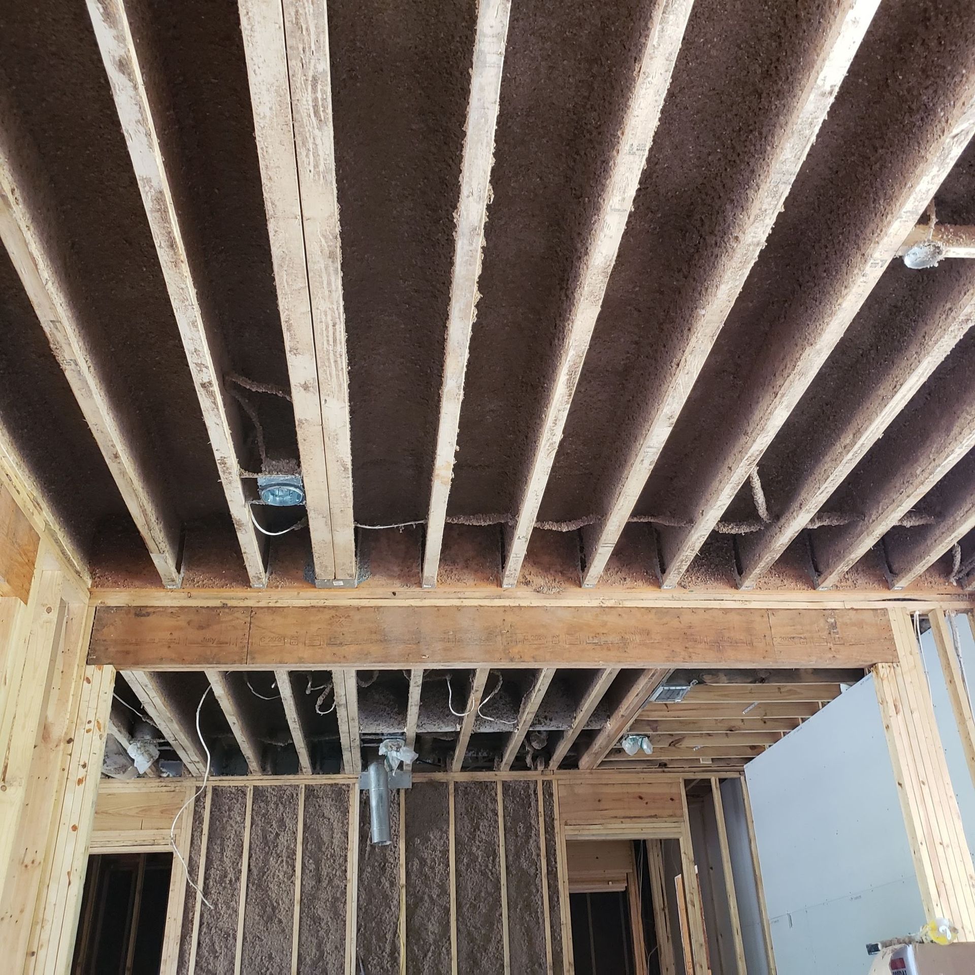 The ceiling of a building under construction with a lot of wood beams