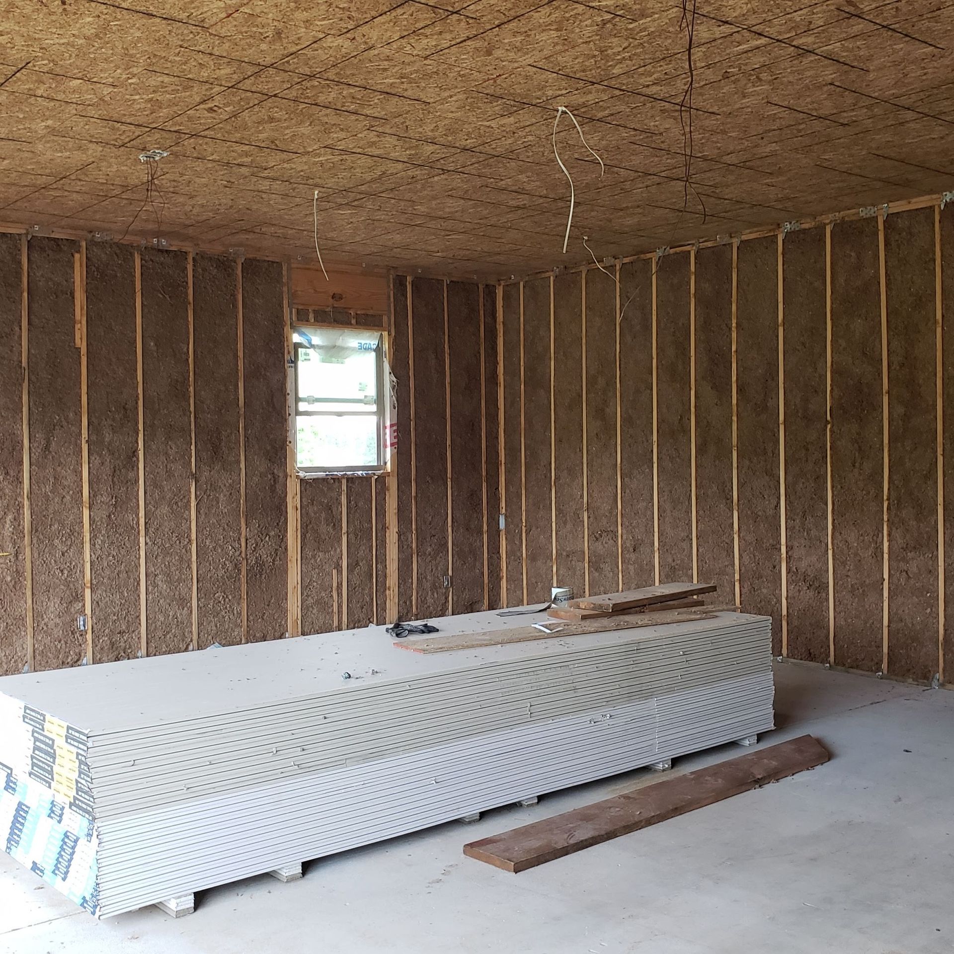 A room with a window and a stack of styrofoam on the floor