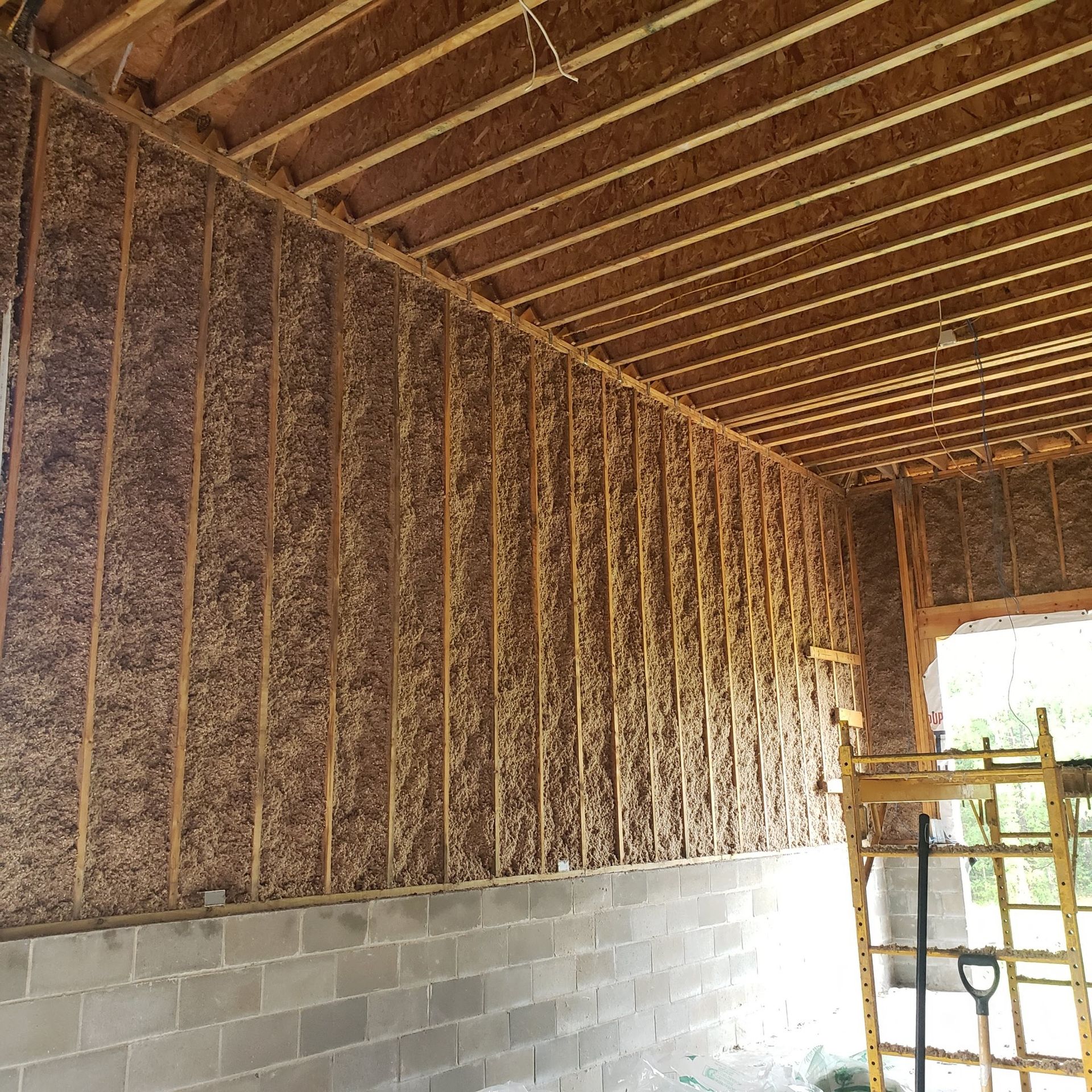 A building under construction with a ladder and a shovel
