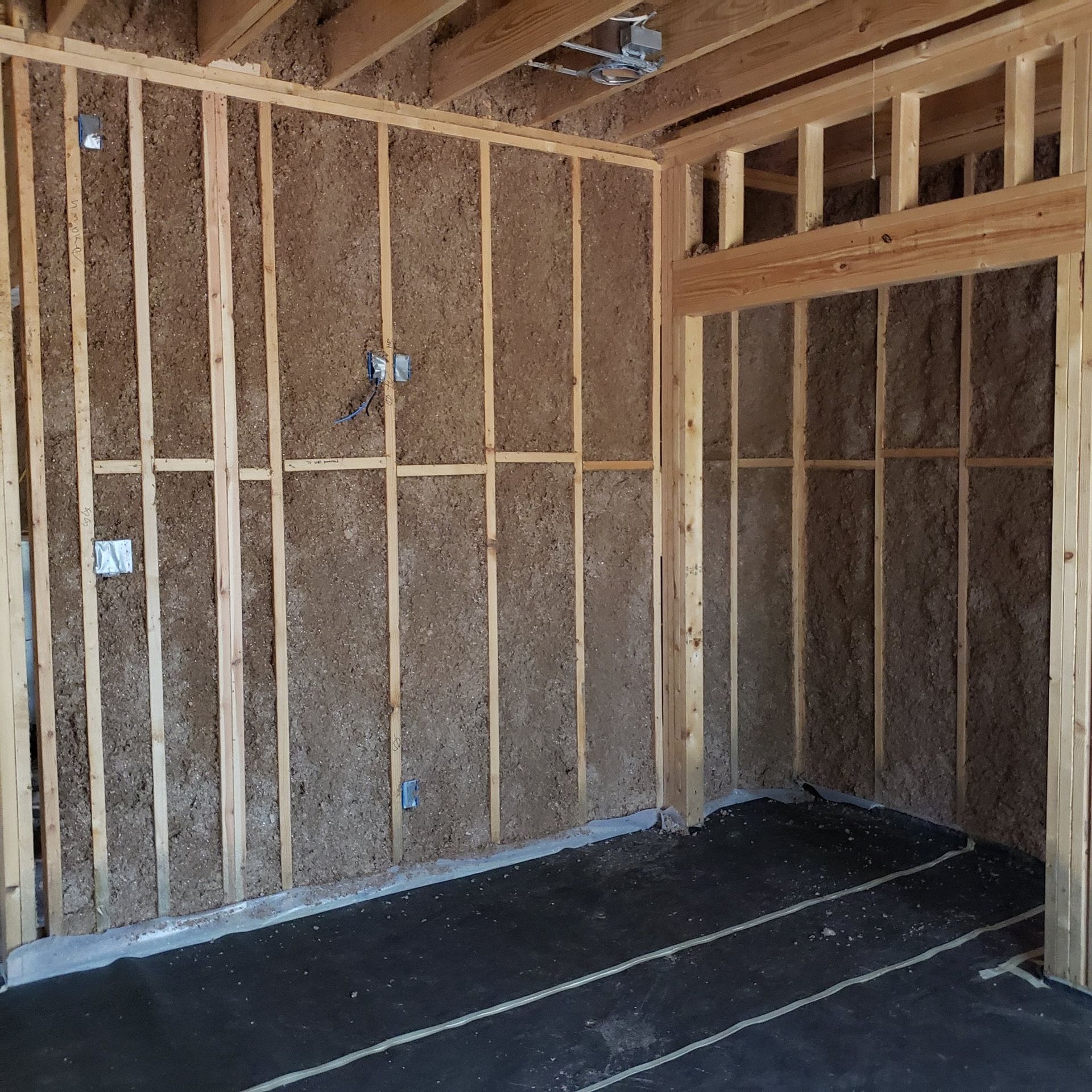An empty room with wooden walls and a black floor