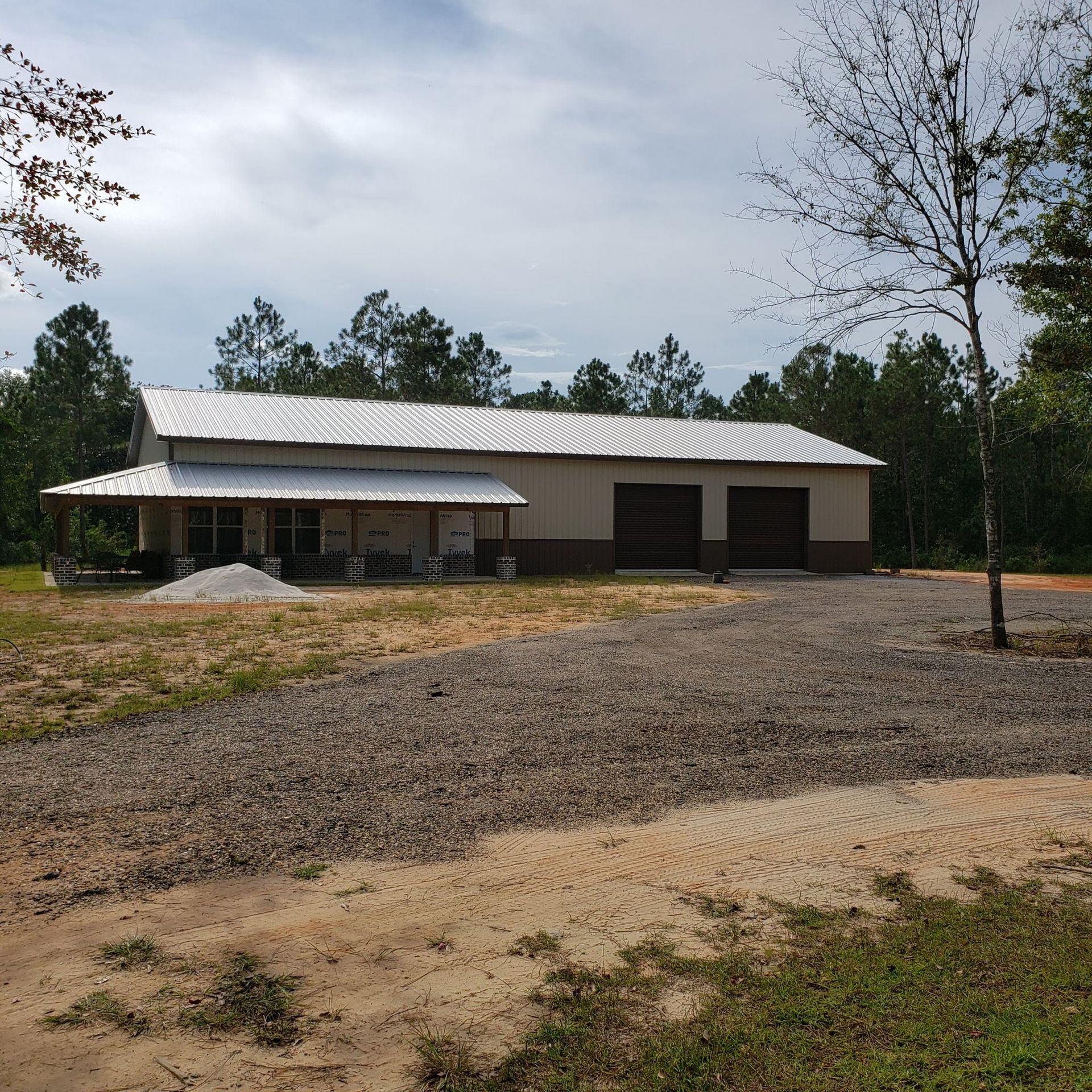 A large white building with a porch and garage doors