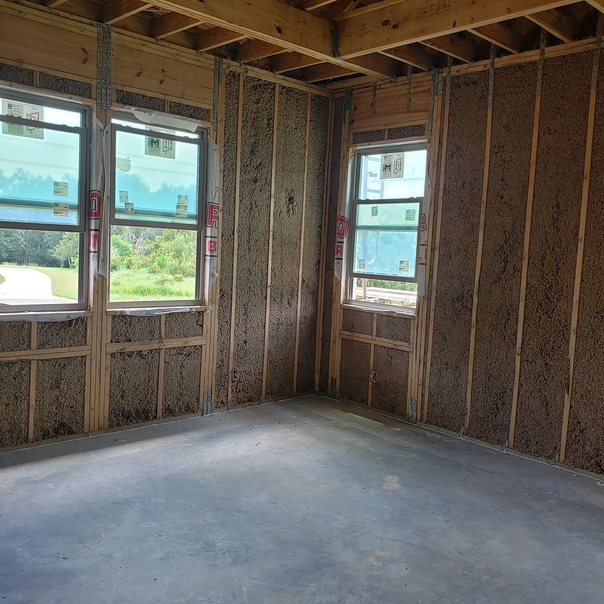 A room with a lot of windows and a concrete floor