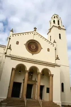 A white church with a clock tower on top of it.