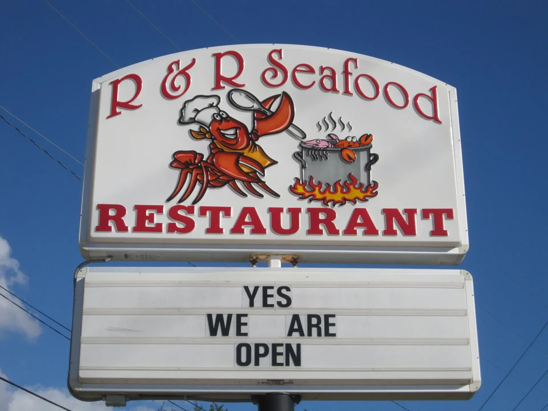 A sign for p & r seafood restaurant says yes we are open