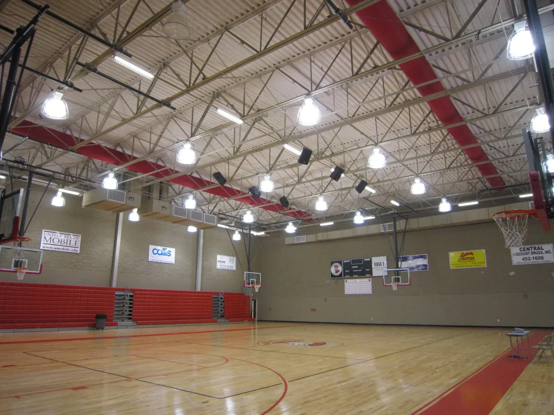 A large indoor basketball court with a ceiling that has a lot of lights on it
