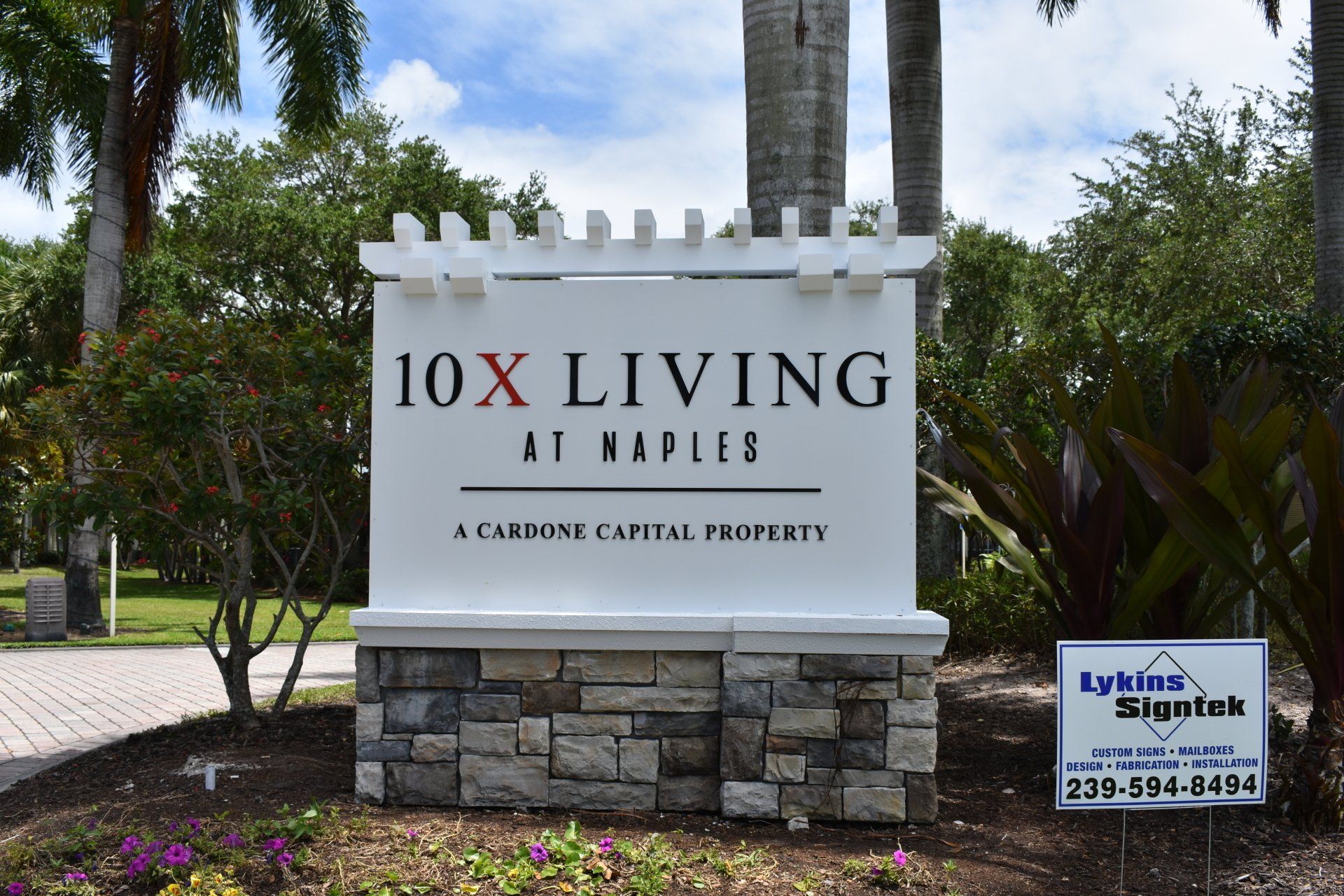 A white sign that says 10x living on it