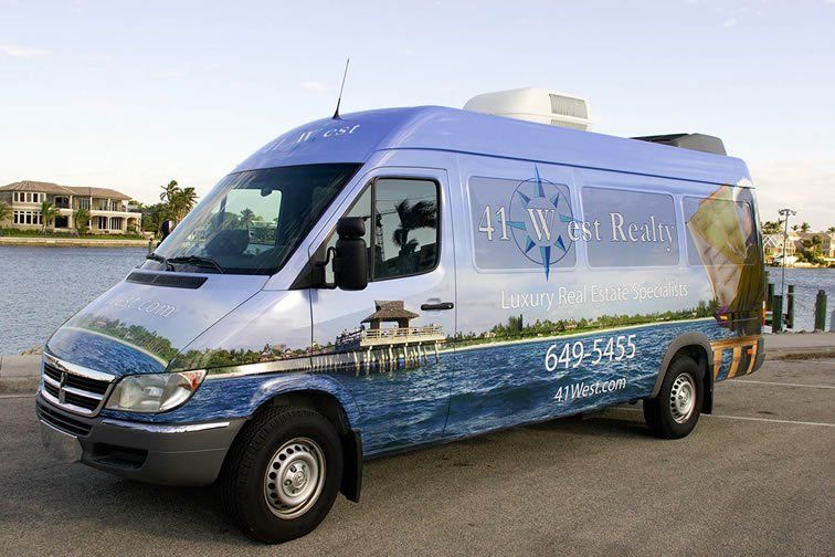 A blue van that says 41 west realty on the side