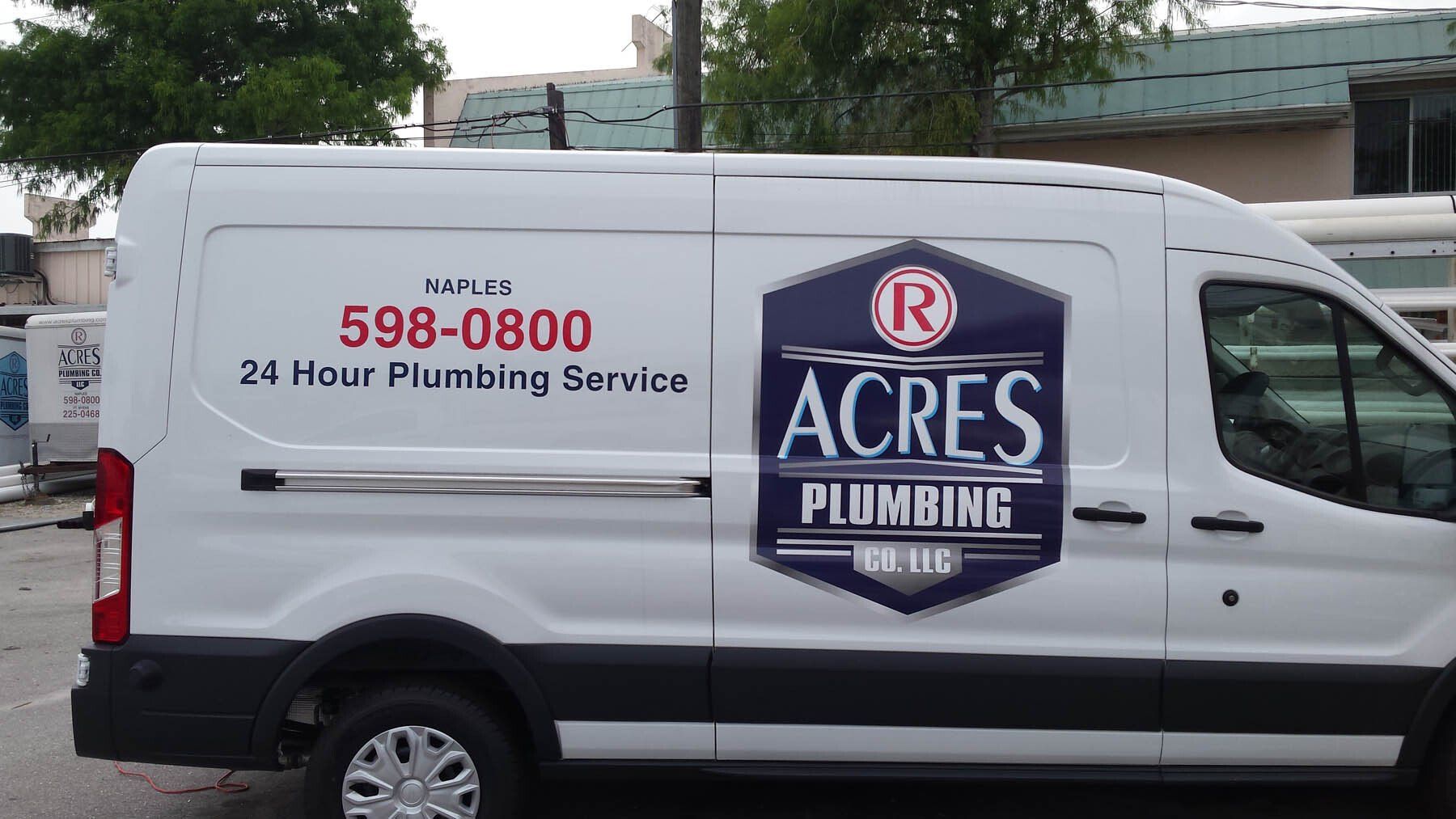 A white van for acres plumbing is parked in a parking lot