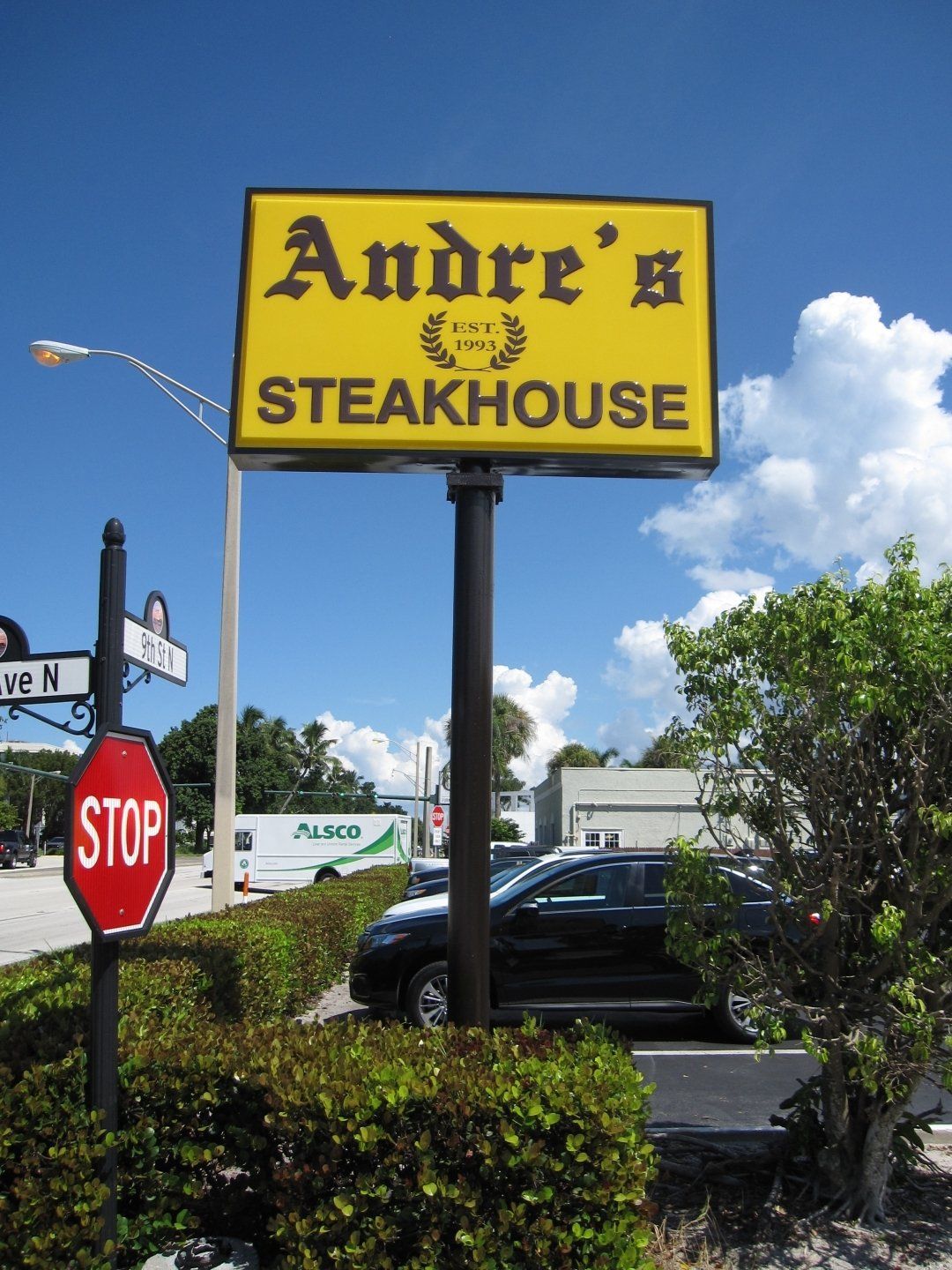 A yellow sign that says andre 's steakhouse on it