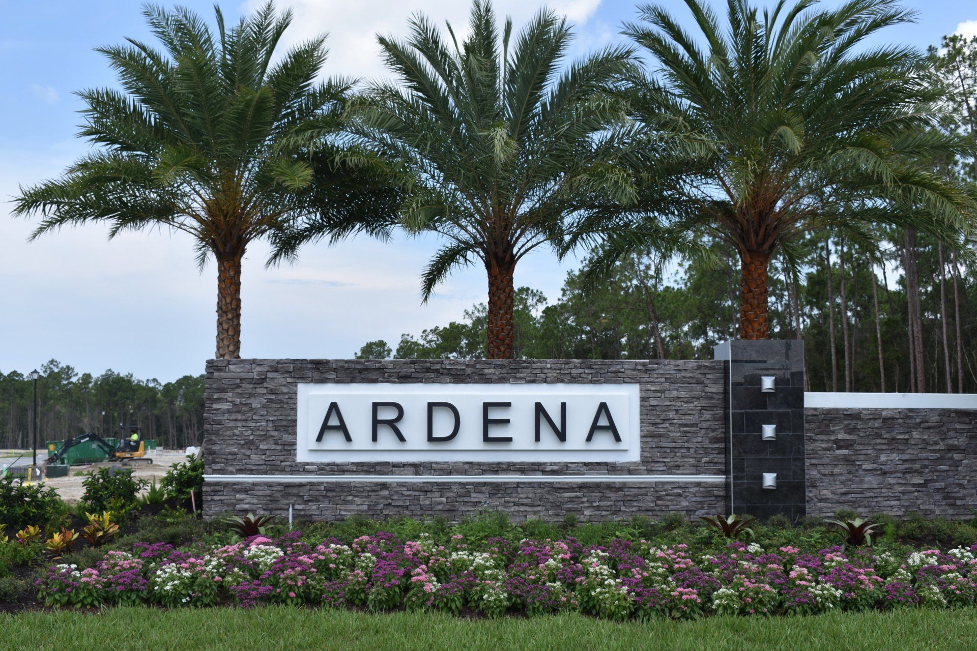 A sign for ardena is surrounded by palm trees