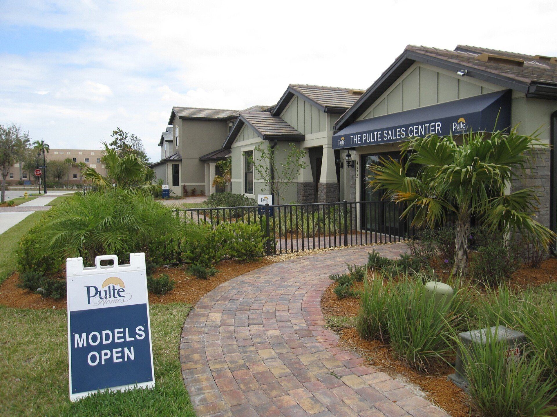 A sign that says ' models open ' on it in front of a house