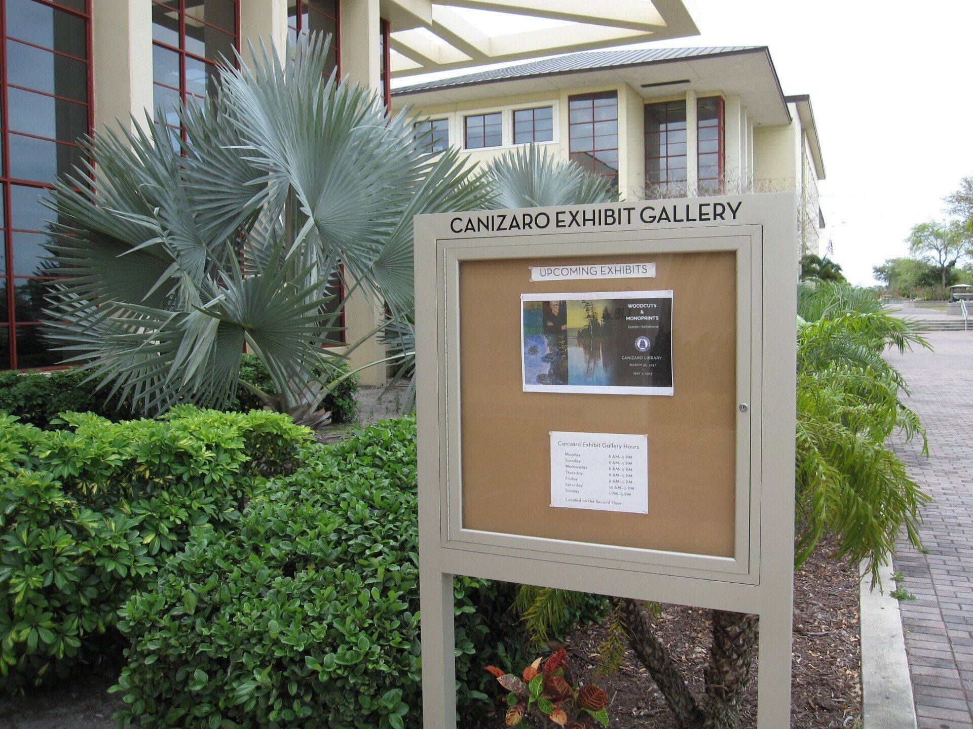 A bulletin board in front of a building that says camzard exhibit gallery