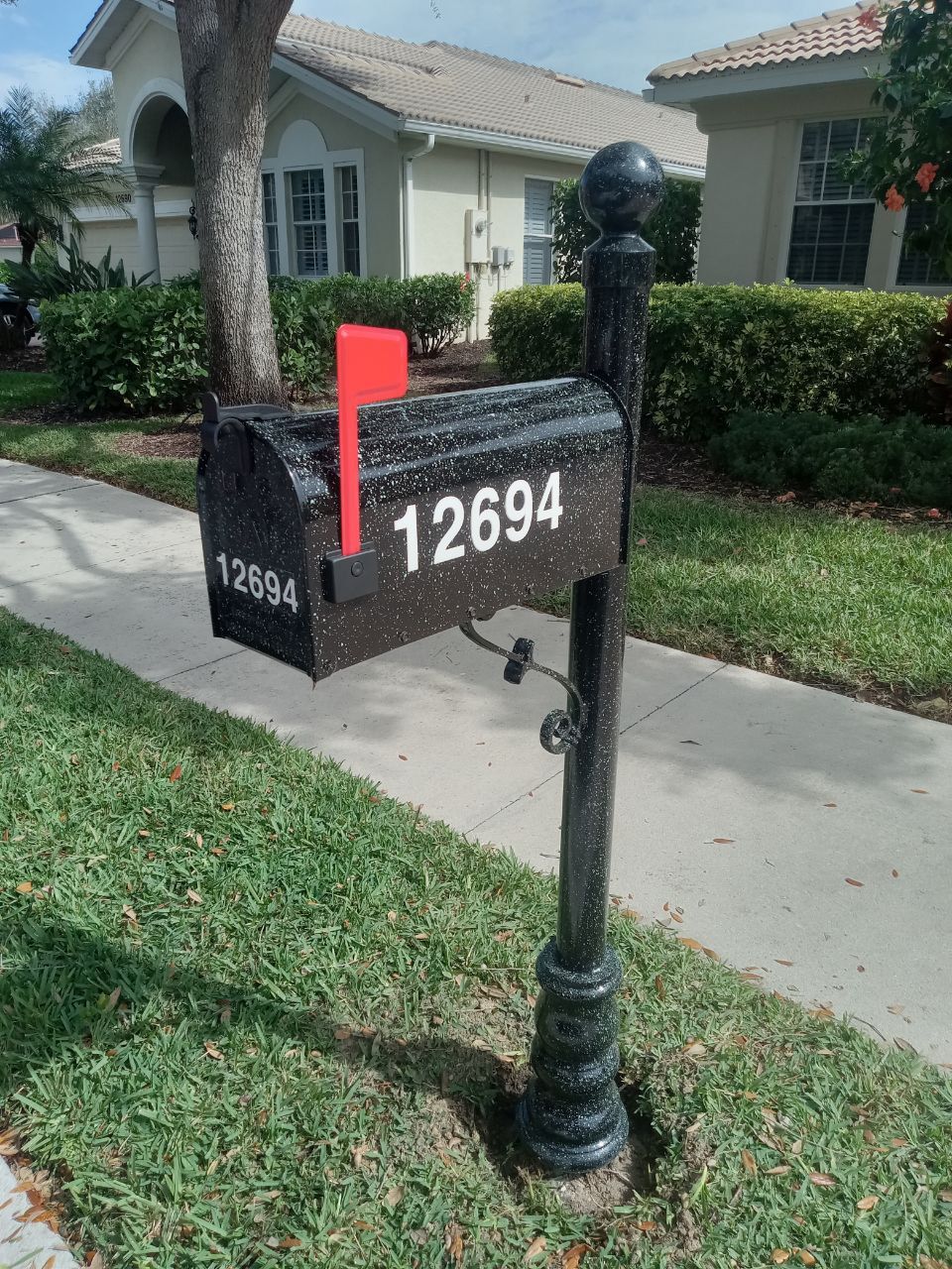 A black mailbox with the number 12694 on it