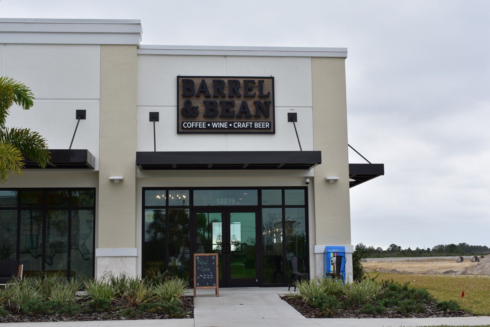 A white building with a sign that says barrel & bean