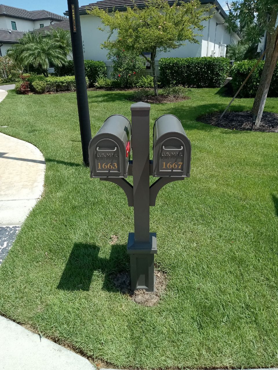A couple of mailboxes sitting on top of a lush green lawn.