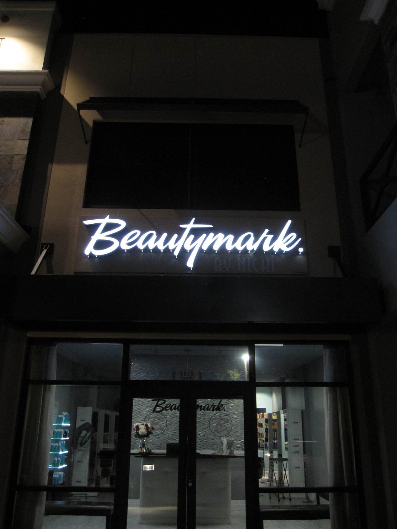 A beautymark sign is lit up at night