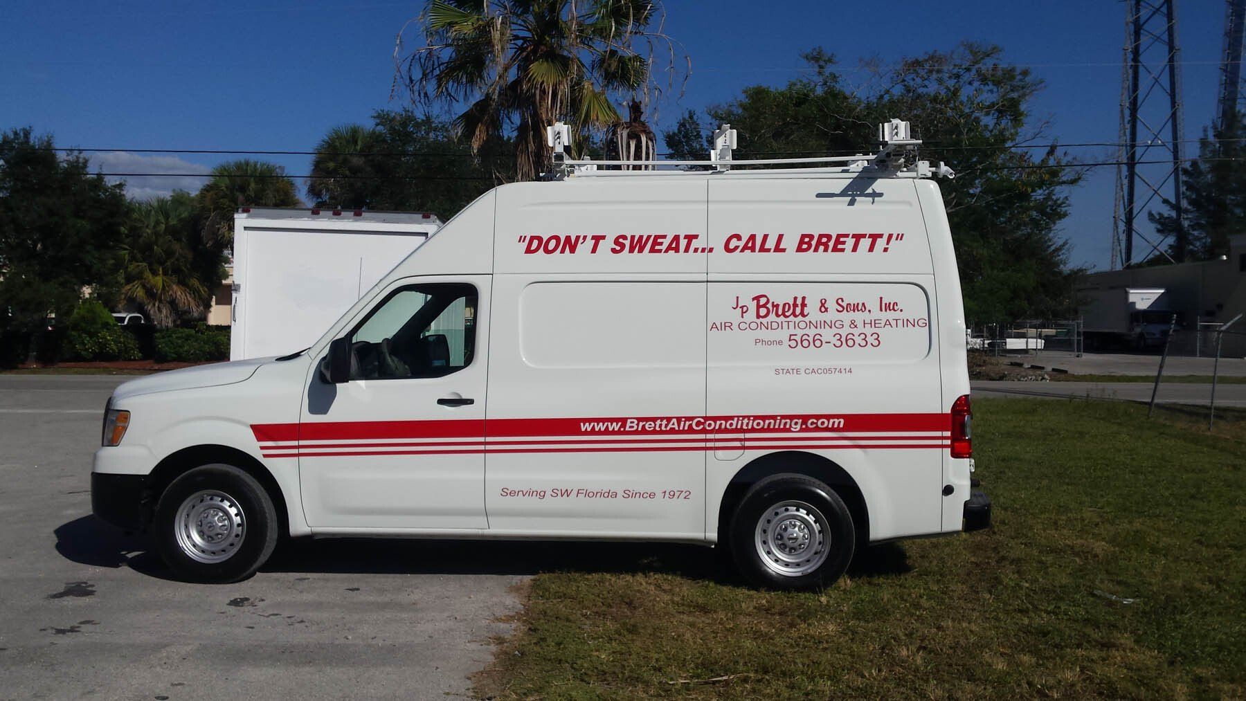 A white van that says ' do n't sweat call brett ' on it
