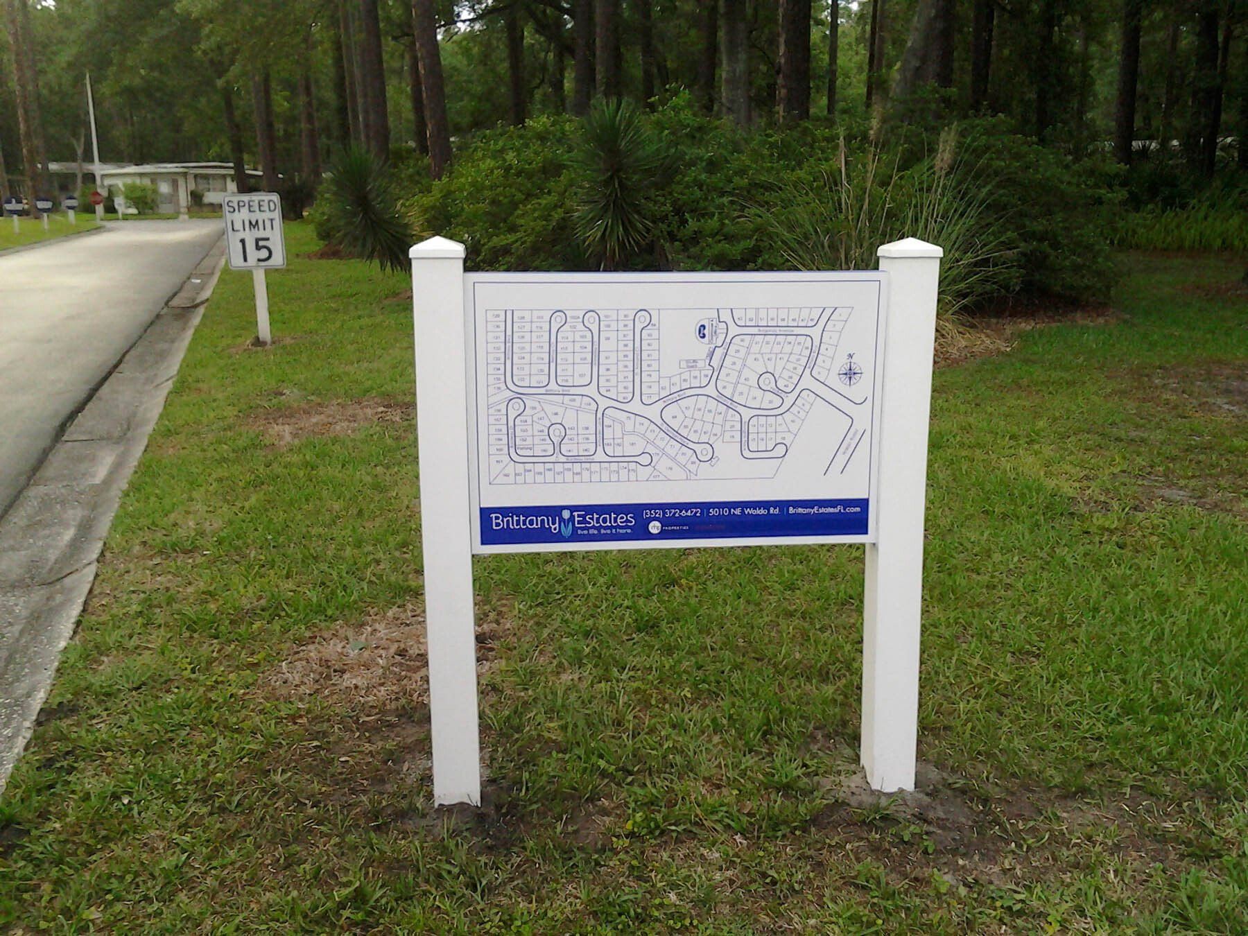 A white sign with a map on it and a speed limit sign in the background
