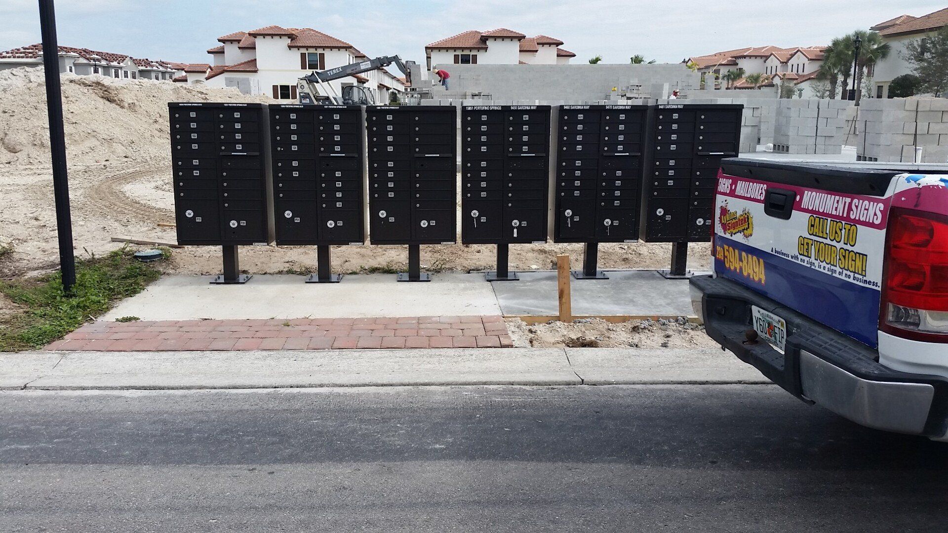 A truck is parked in front of a row of mailboxes
