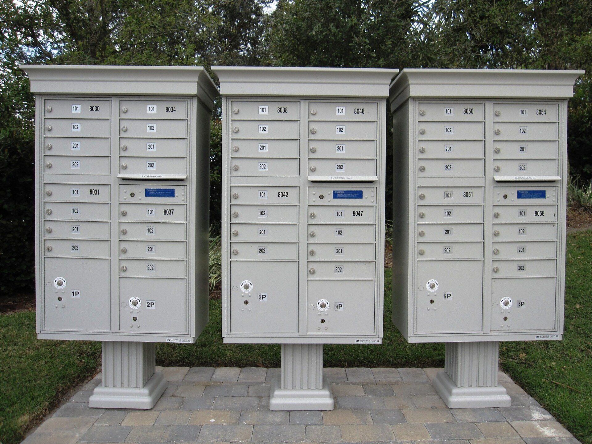 Three white mailboxes are lined up in a row
