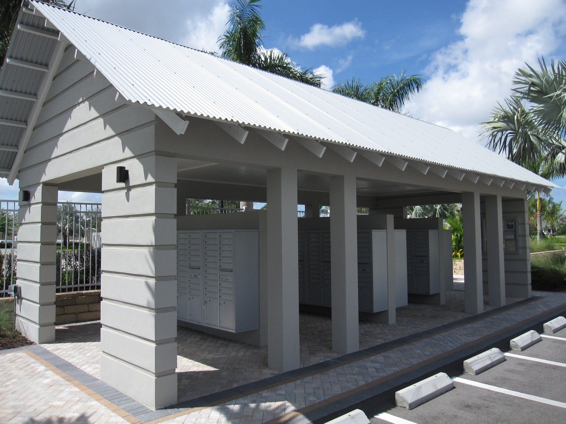 A white building with a white roof sits in a parking lot