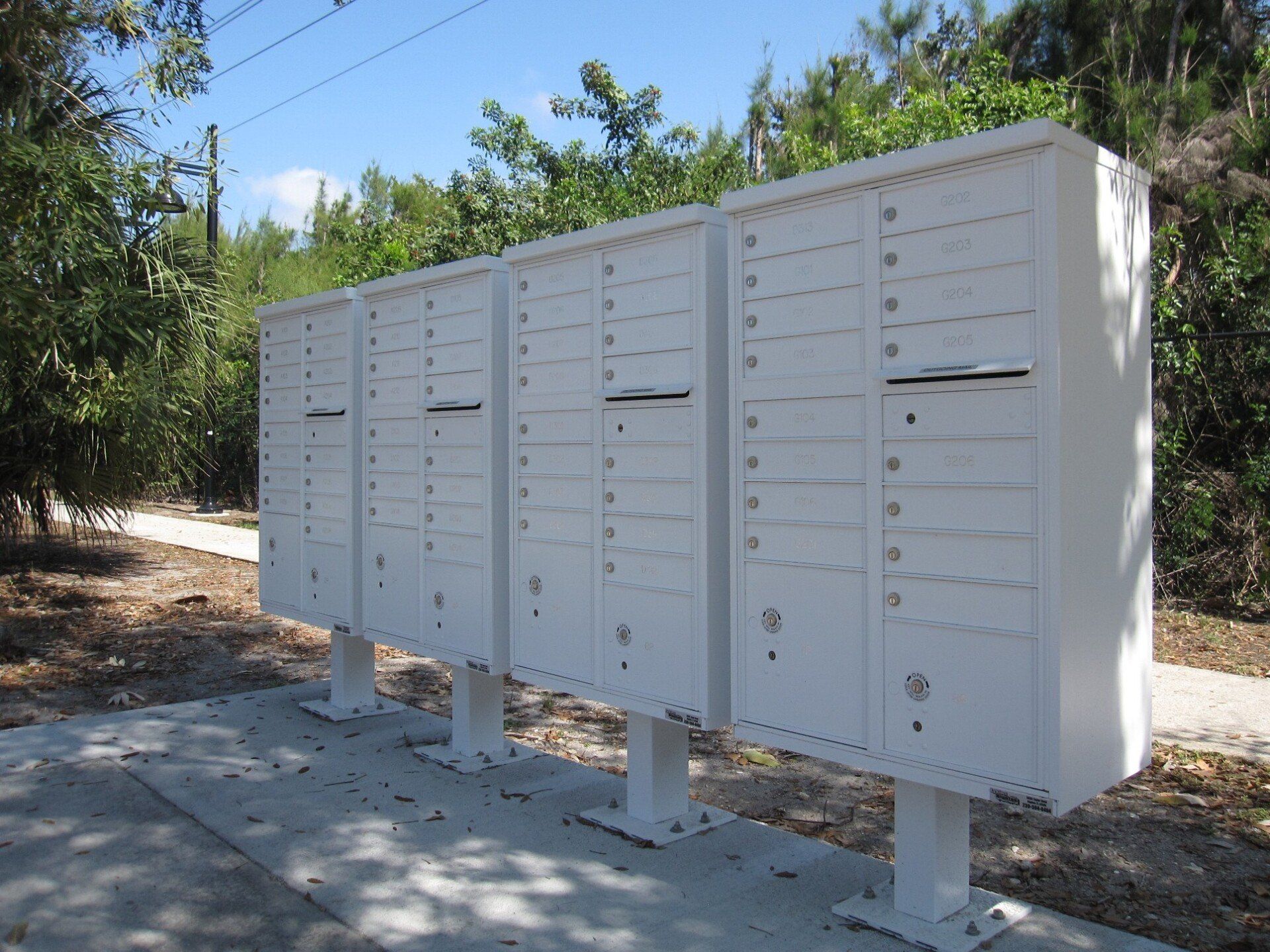 A row of white mailboxes are lined up next to each other