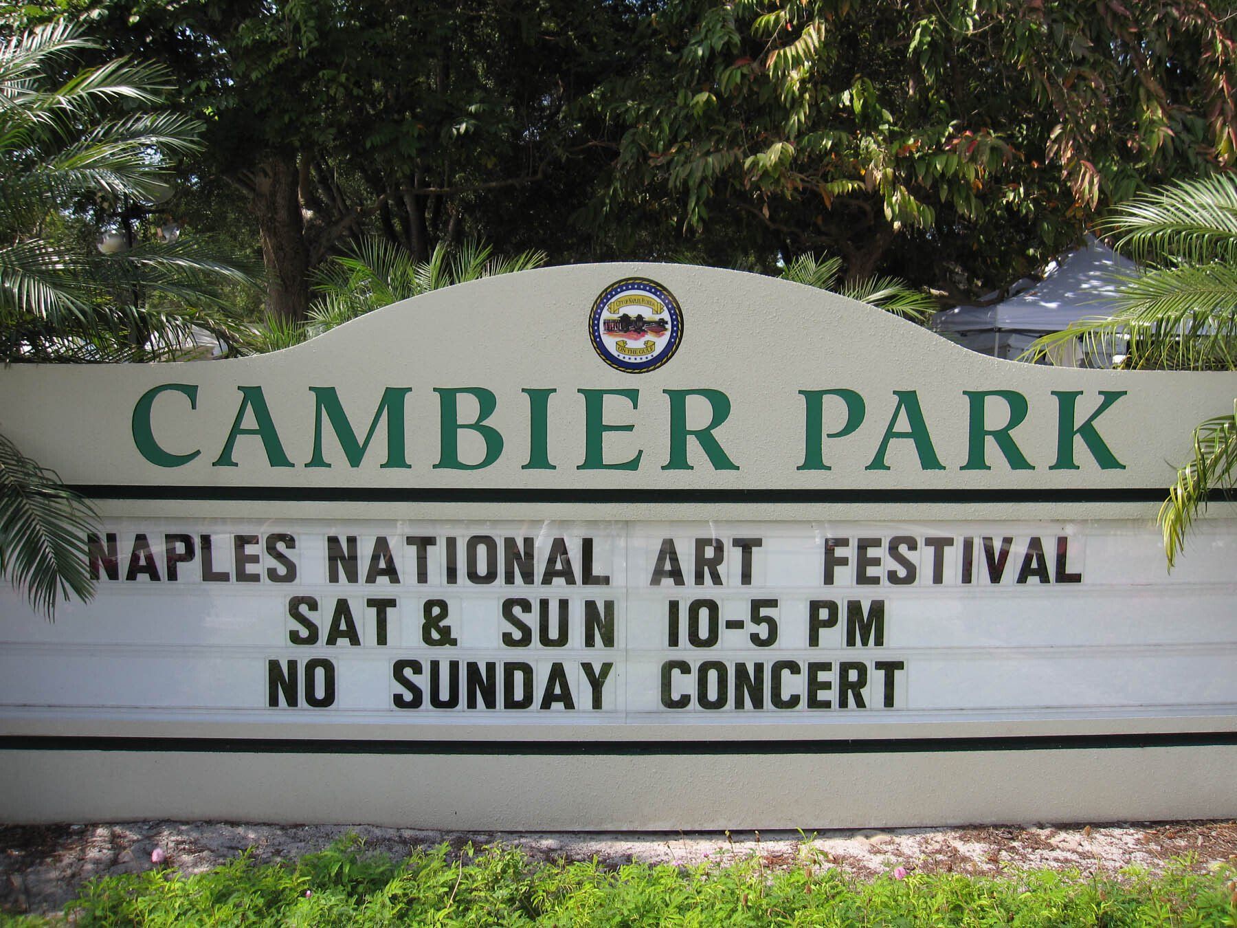 A sign for cambier park says naples national art festival sat & sun 10-5 pm no sunday concert