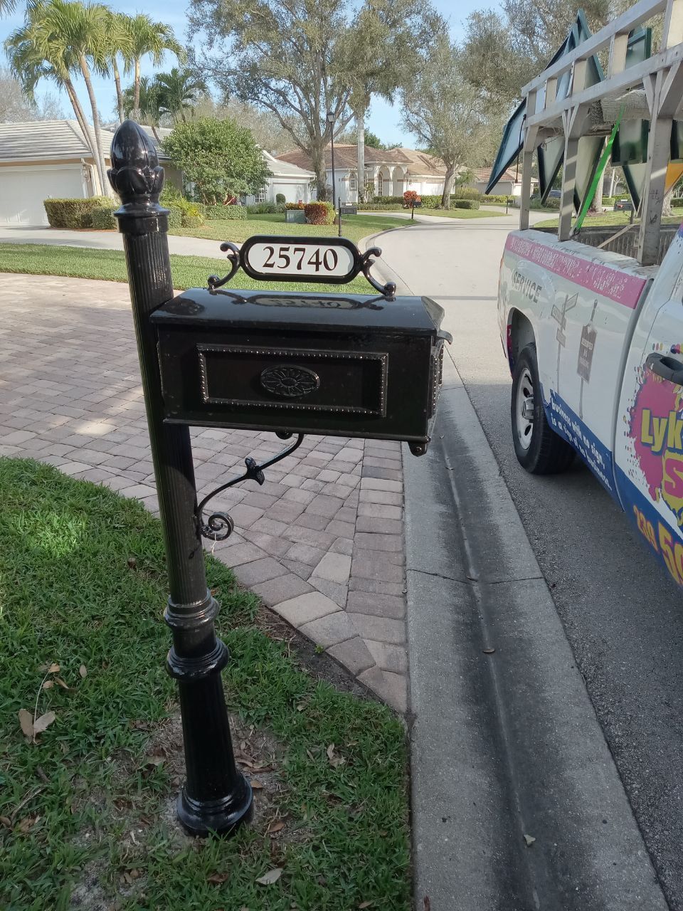 A mailbox on the side of the road next to a truck.