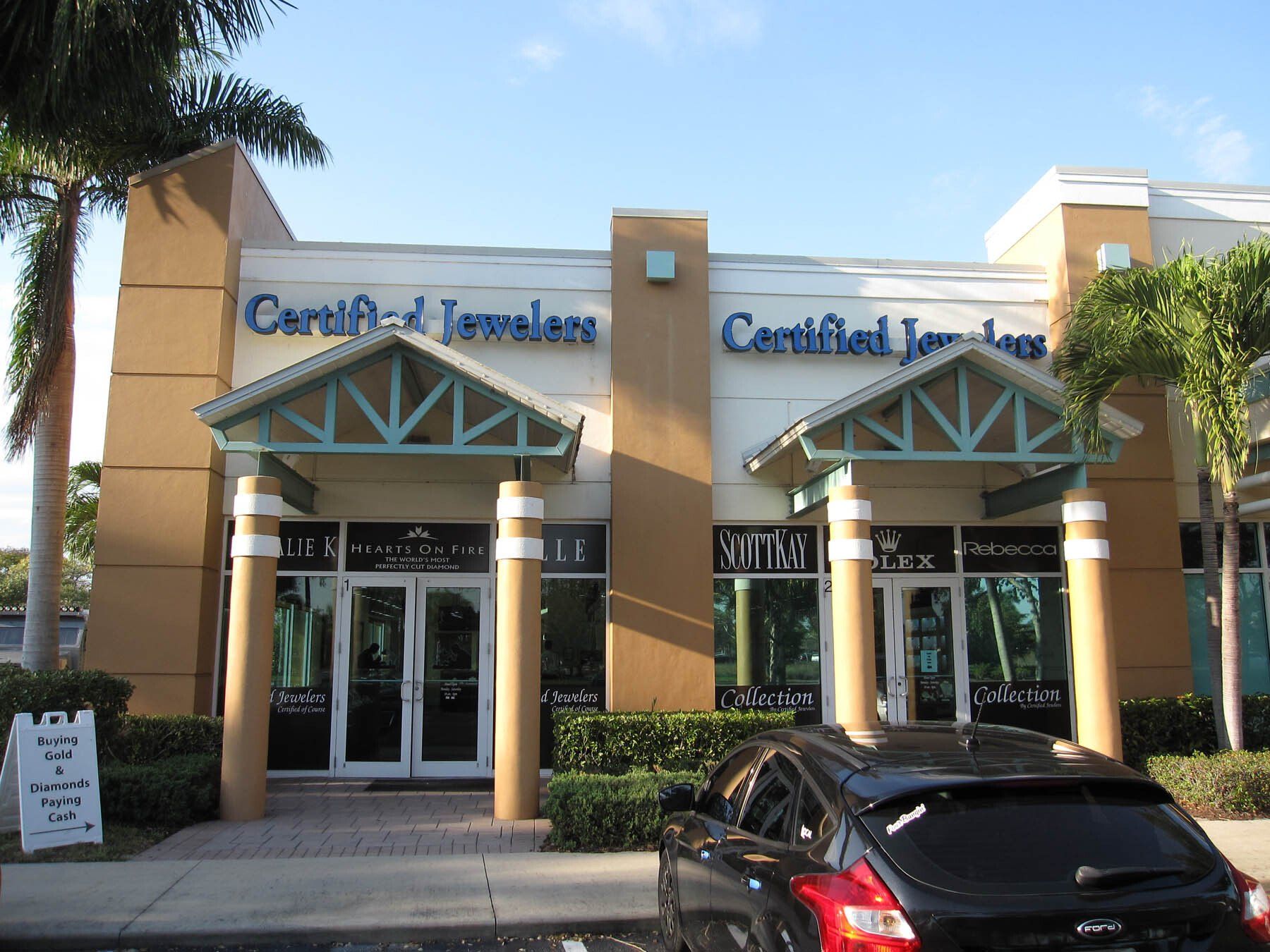 A car is parked in front of a certified jewelers store