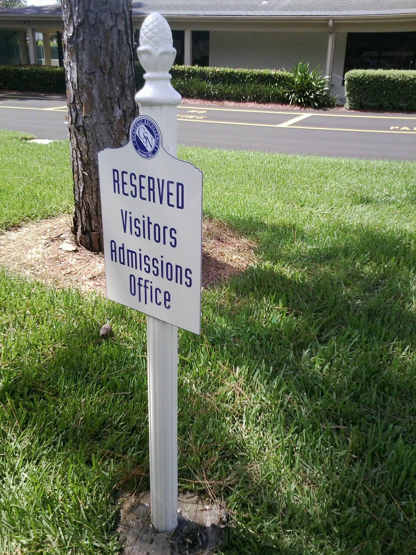 A white sign that says reserved visitors admissions office