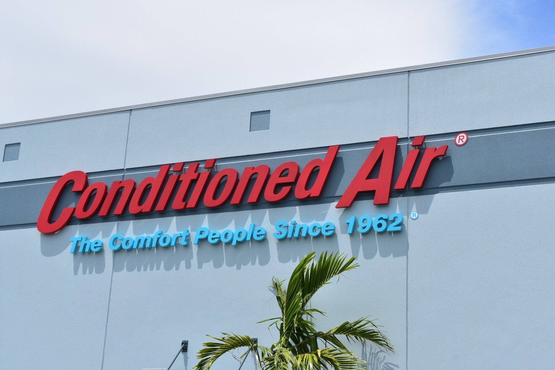 A building with a sign that says ' conditioned air ' on it