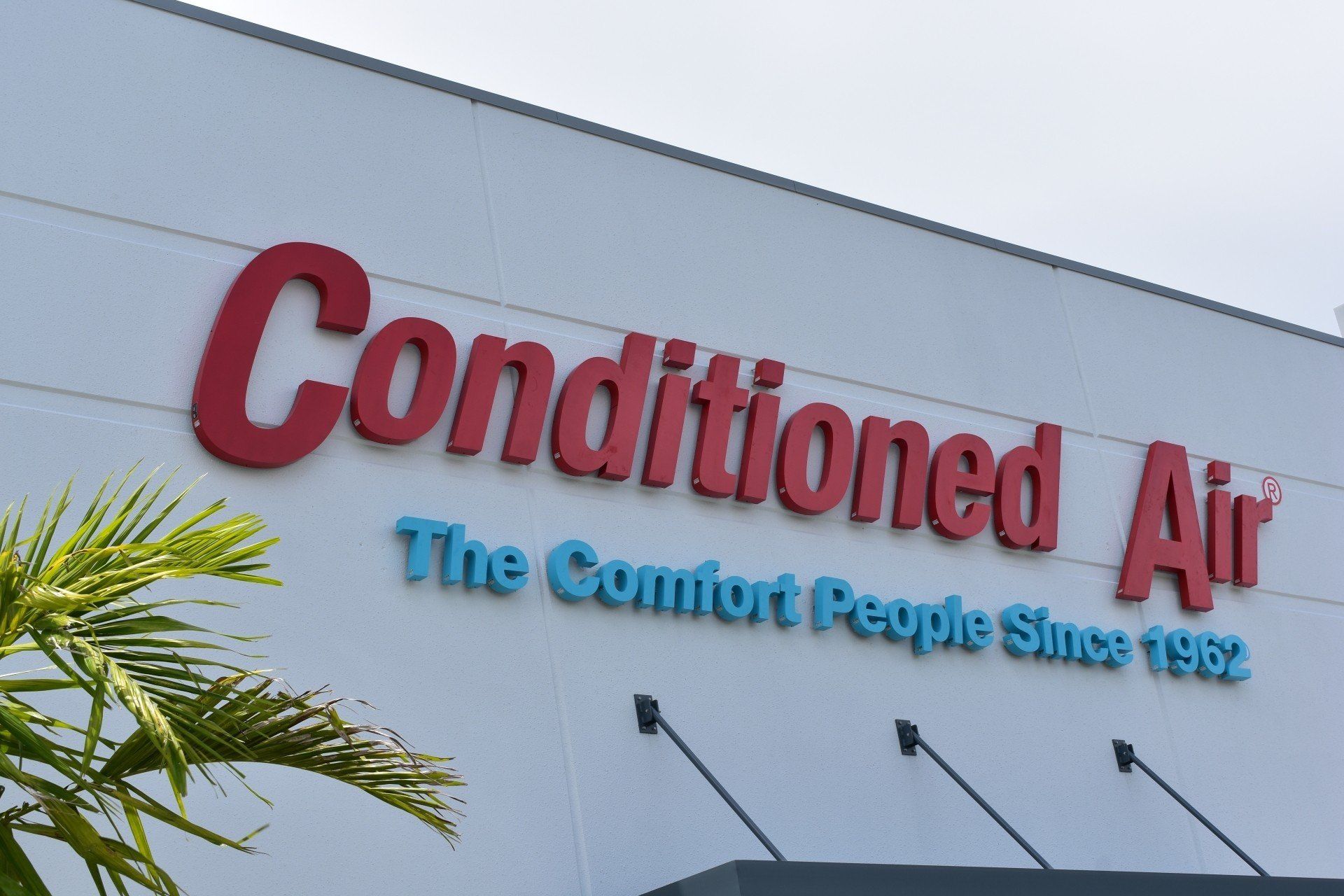 The outside of a building that says ' conditioned air ' on it
